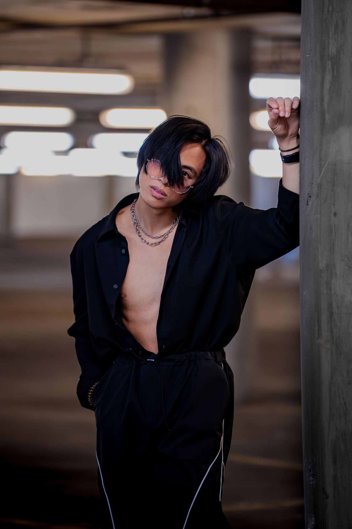 Dramatic portrait series in parking garage featuring black blazer and moody lighting.