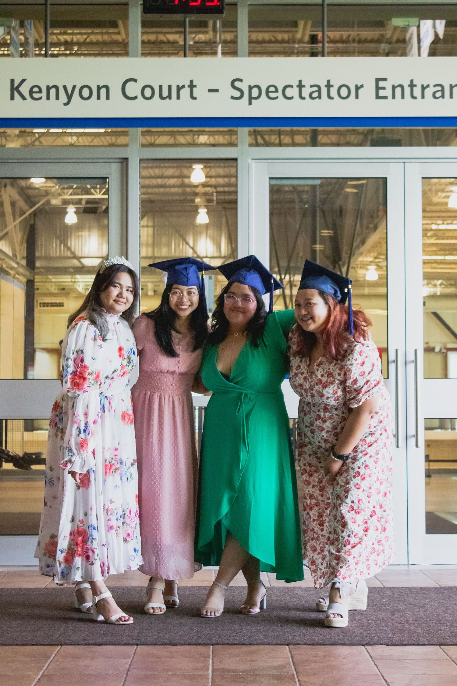 Group photo outside Kenyon Court entrance wearing colorful formal dresses.
