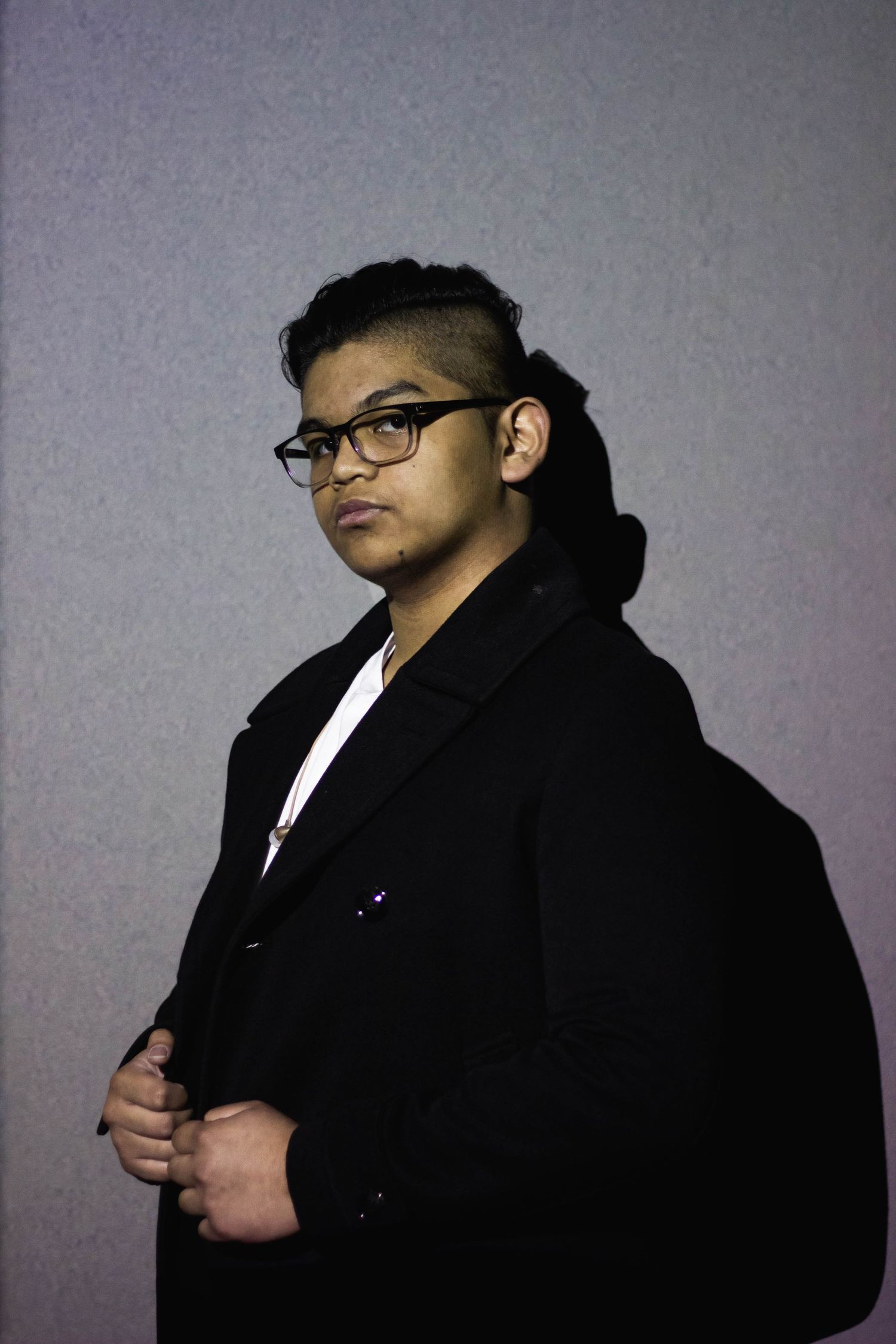 Artistic silhouette portraits against a gray background showing different poses in black attire.