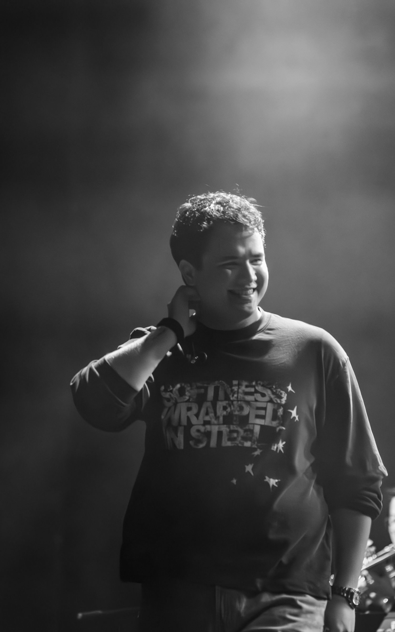 Musicians performing in dark lighting wearing fitness-themed t-shirts.