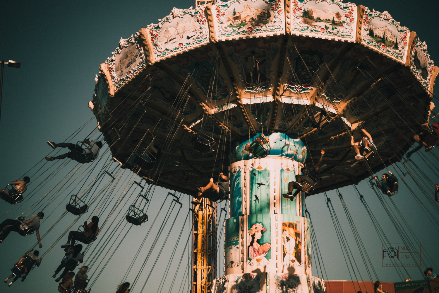 Vintage carousel with ornate decorations illuminated against a dark background.