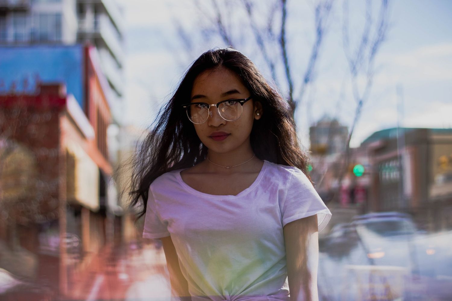 A series of portraits showing a person in casual attire against an urban backdrop with blurred buildings.