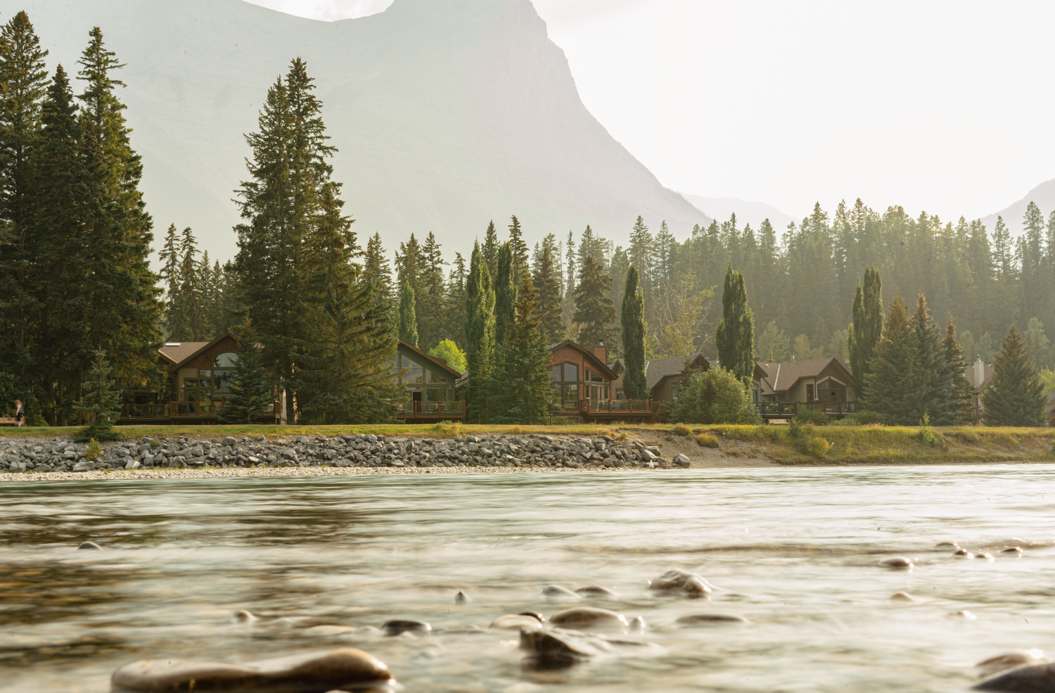 Serene mountain lake landscape with evergreen trees and misty atmosphere.