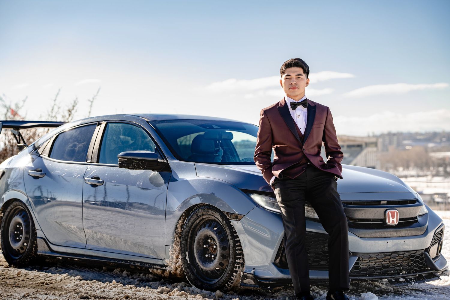 Professional photoshoot featuring luxury cars in an outdoor winter setting.