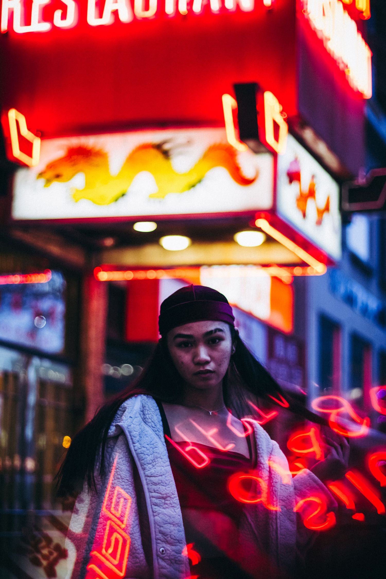 Nighttime street photography with vibrant red neon signs creating a cyberpunk aesthetic.