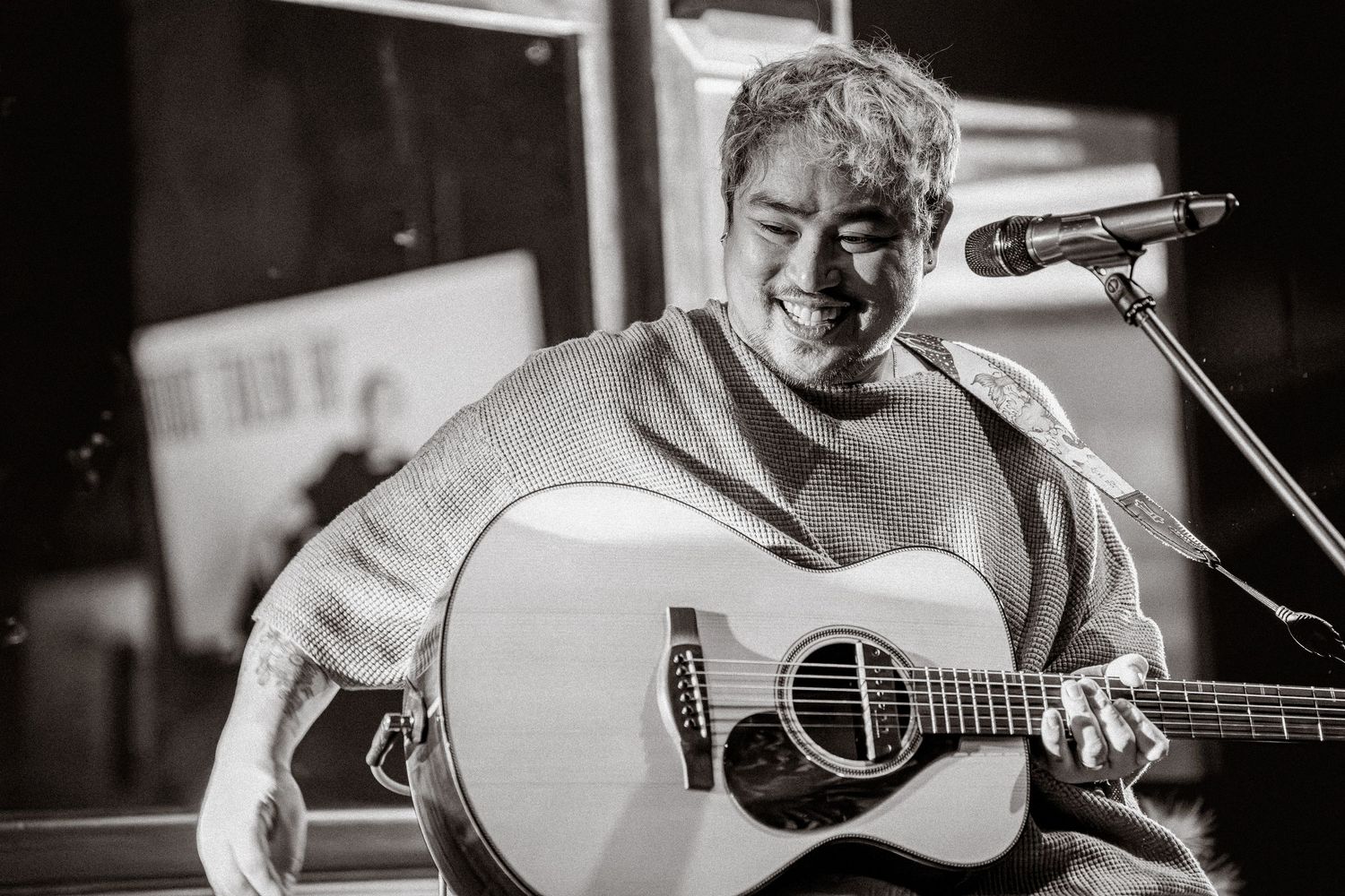 Musicians performing with acoustic guitars in an intimate venue setting.