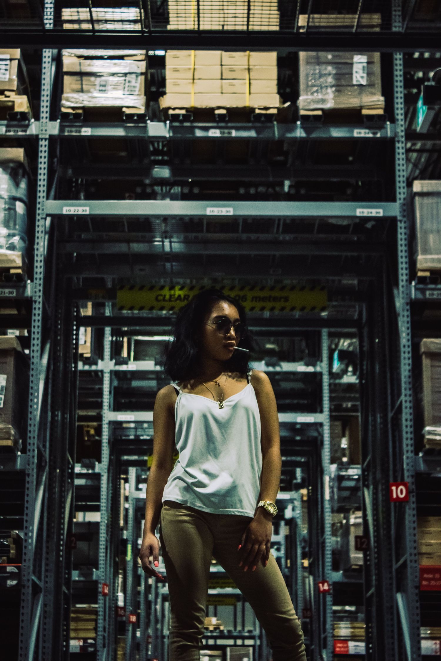 Industrial warehouse interior with metal shelving and dramatic lighting effects.