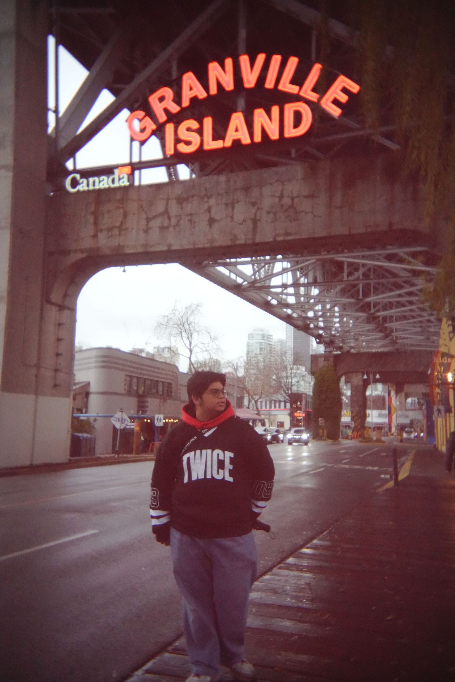 Urban scene under Granville Island sign with moody lighting and architecture.