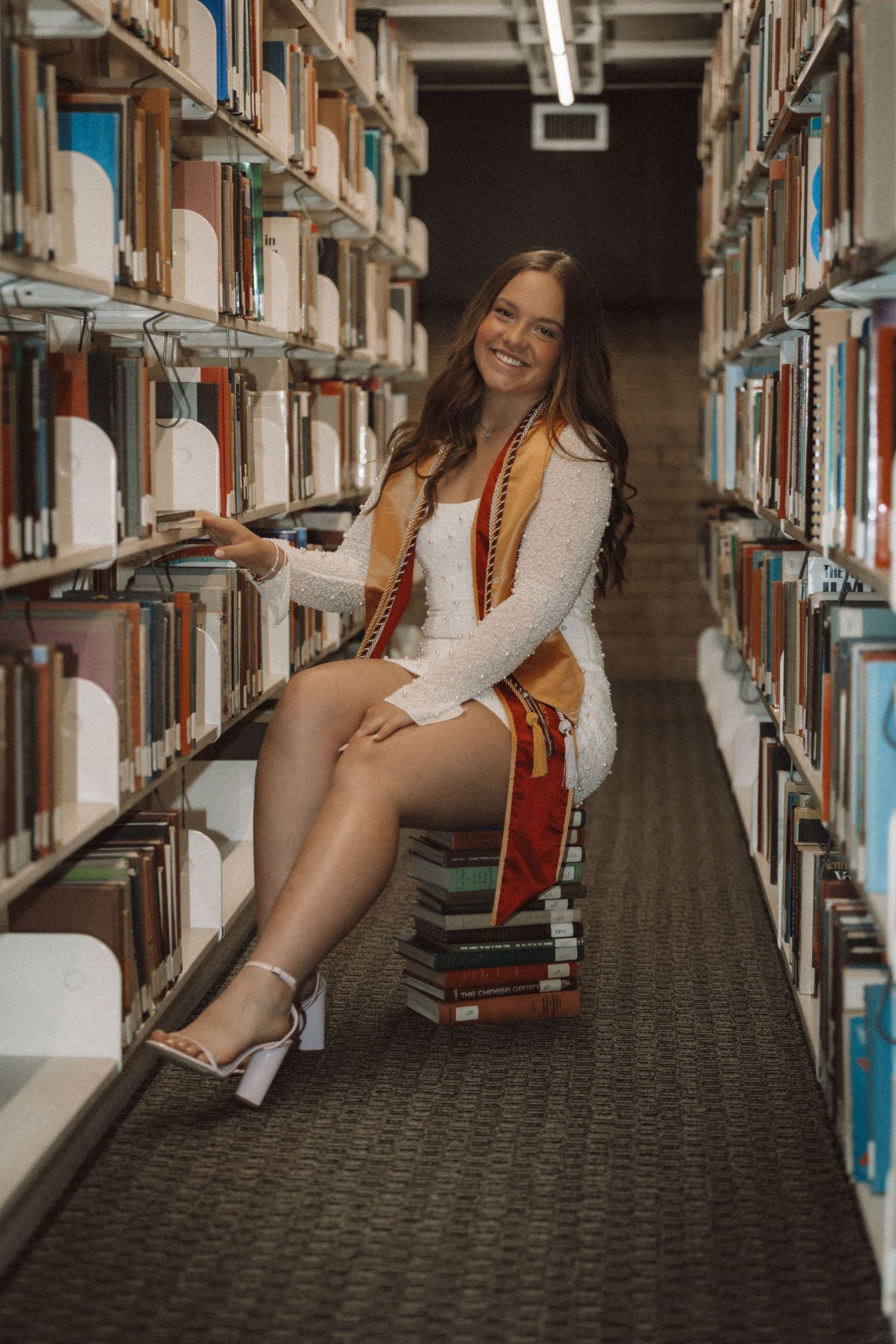 Fun candid poses between library bookshelves showing casual style and personality.