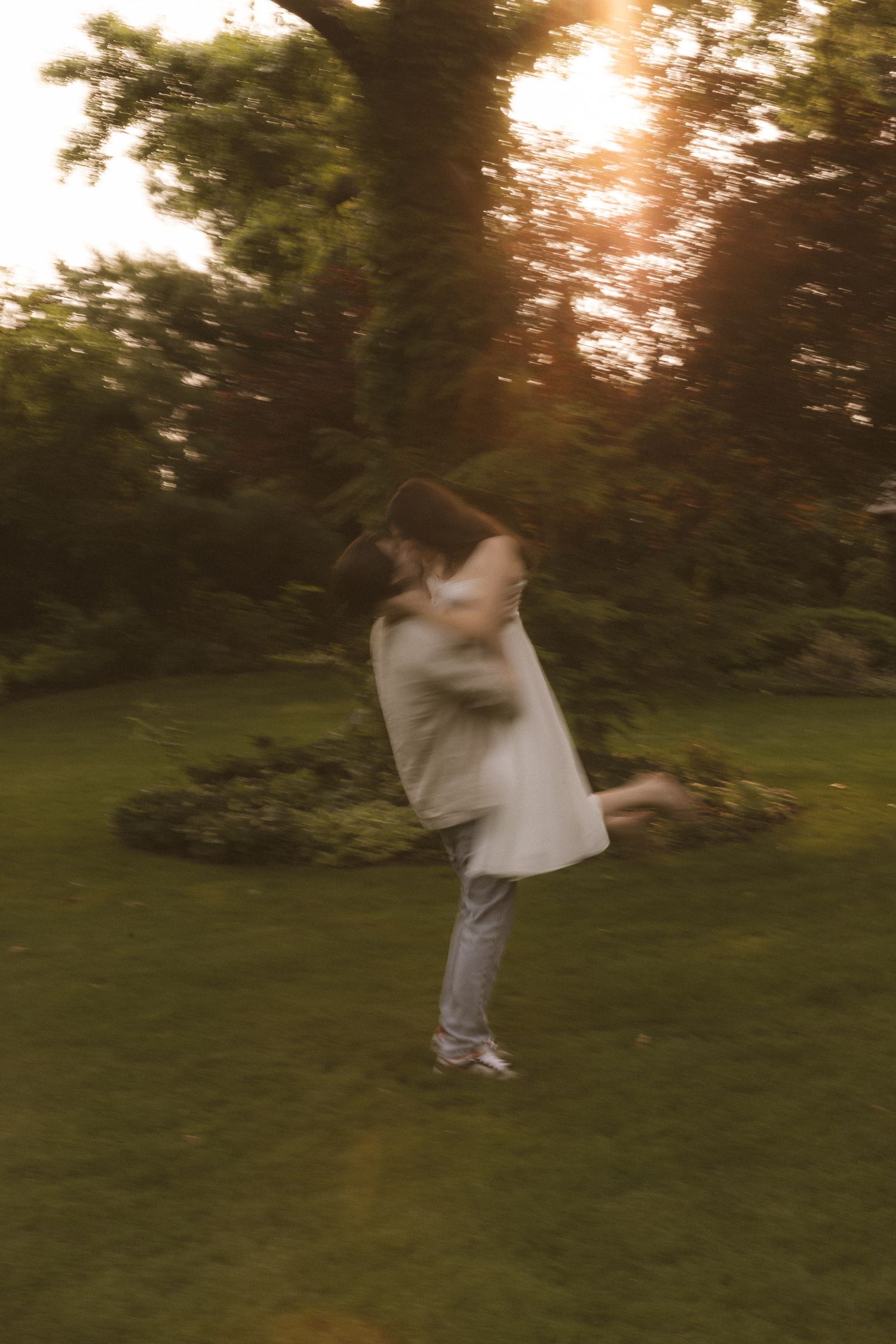 Motion sequence of people dancing and spinning in a sunlit garden.