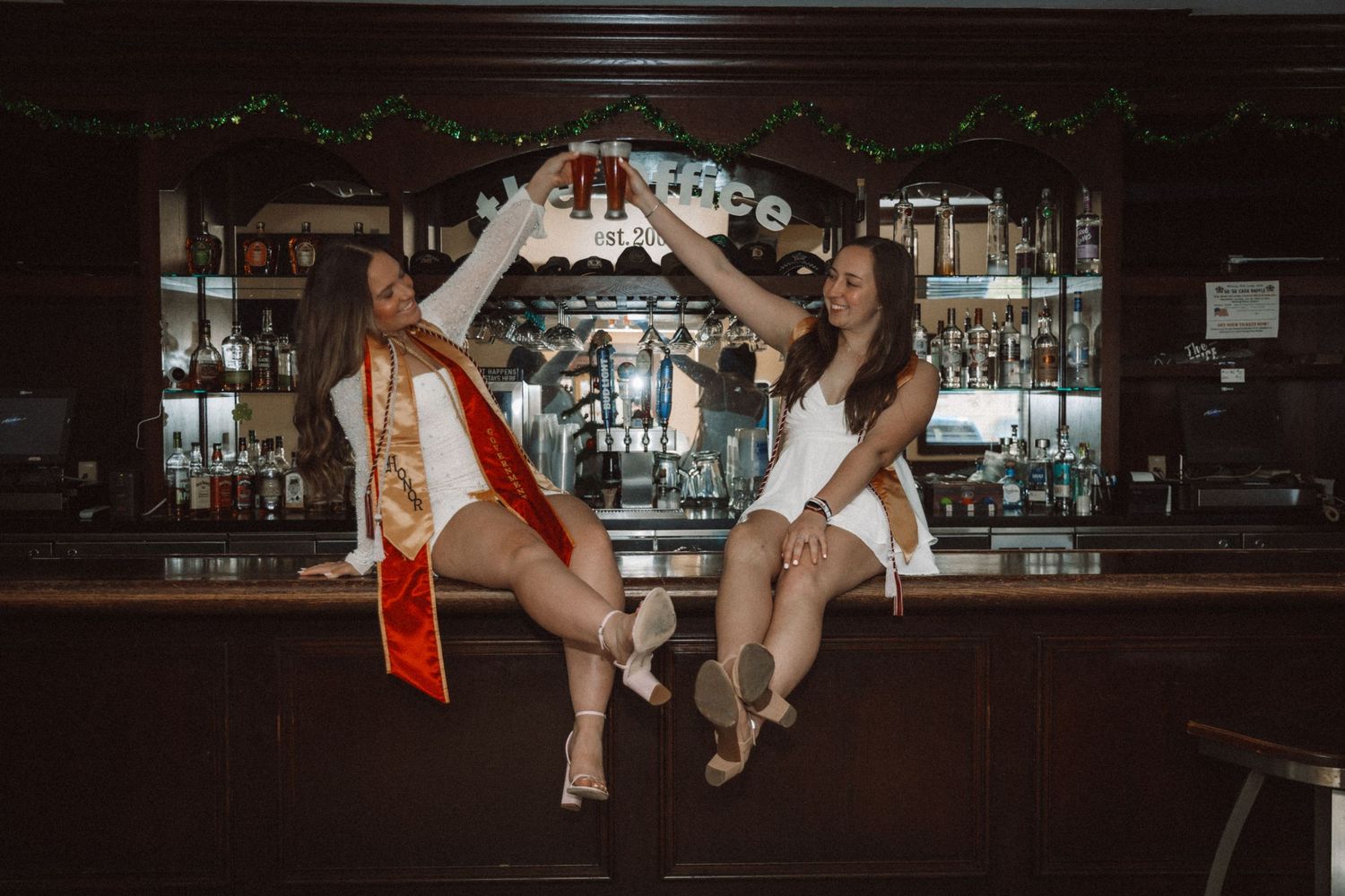 Stylish bar photoshoot with modern casual attire and dramatic lighting.