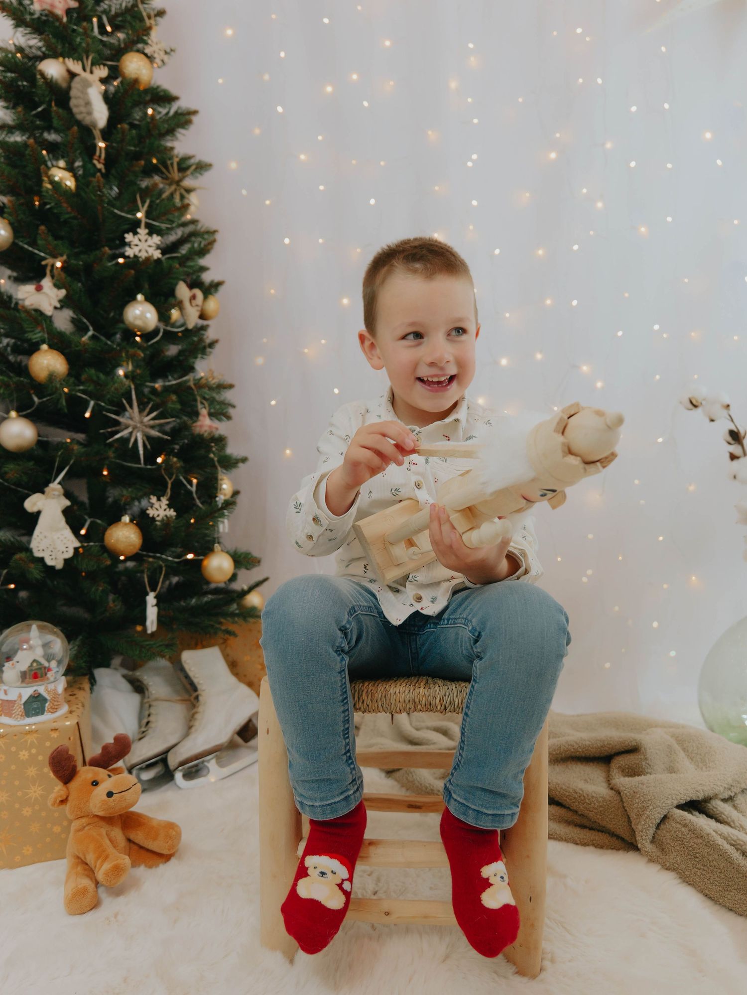 Petit garçon qui tient un casse noisette devant un décor de noël