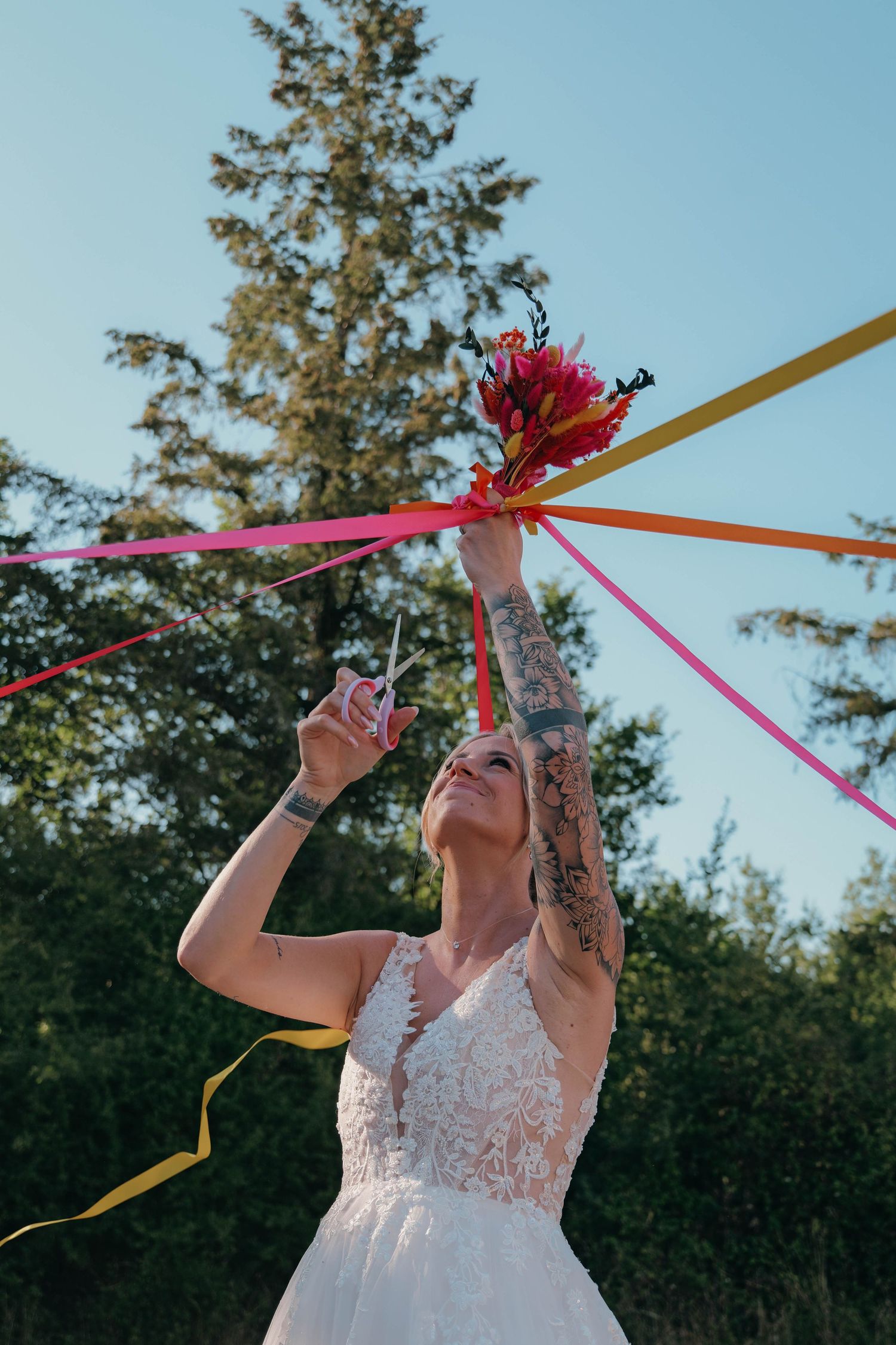 La mariée qui fait le jeu des rubans pour le bouquet