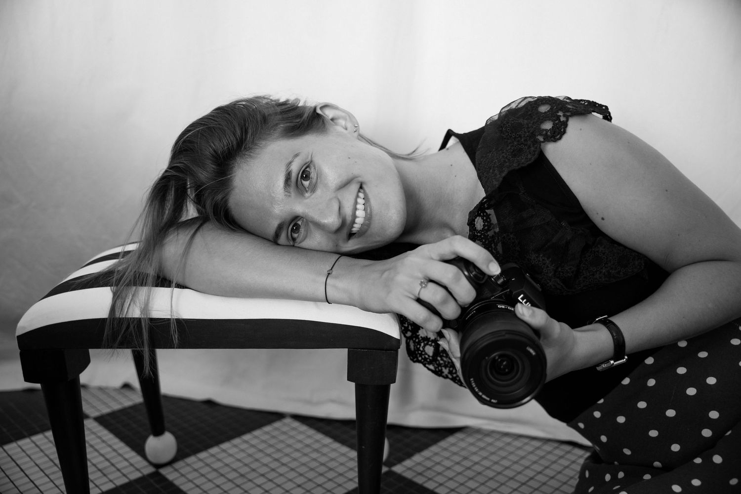Portrait de la photographe, en noir et blanc, qui tient son appareil photo.