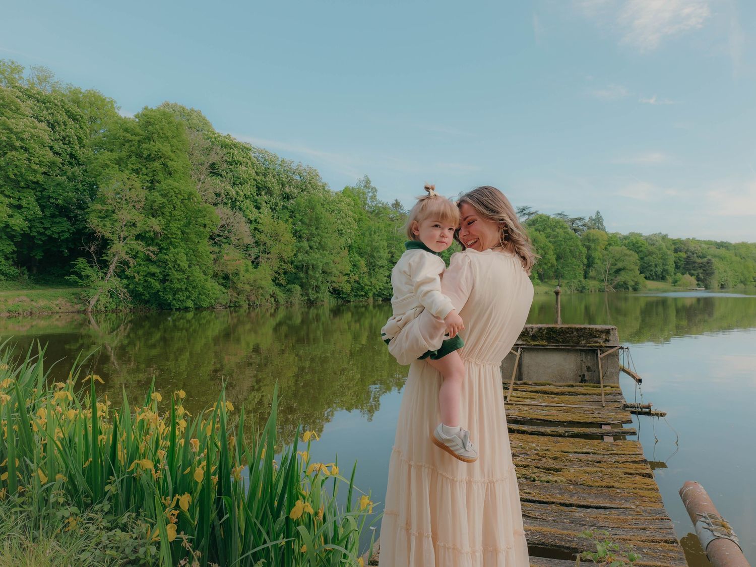 Une mère et sa fille qui se font un câlin devant un lac.