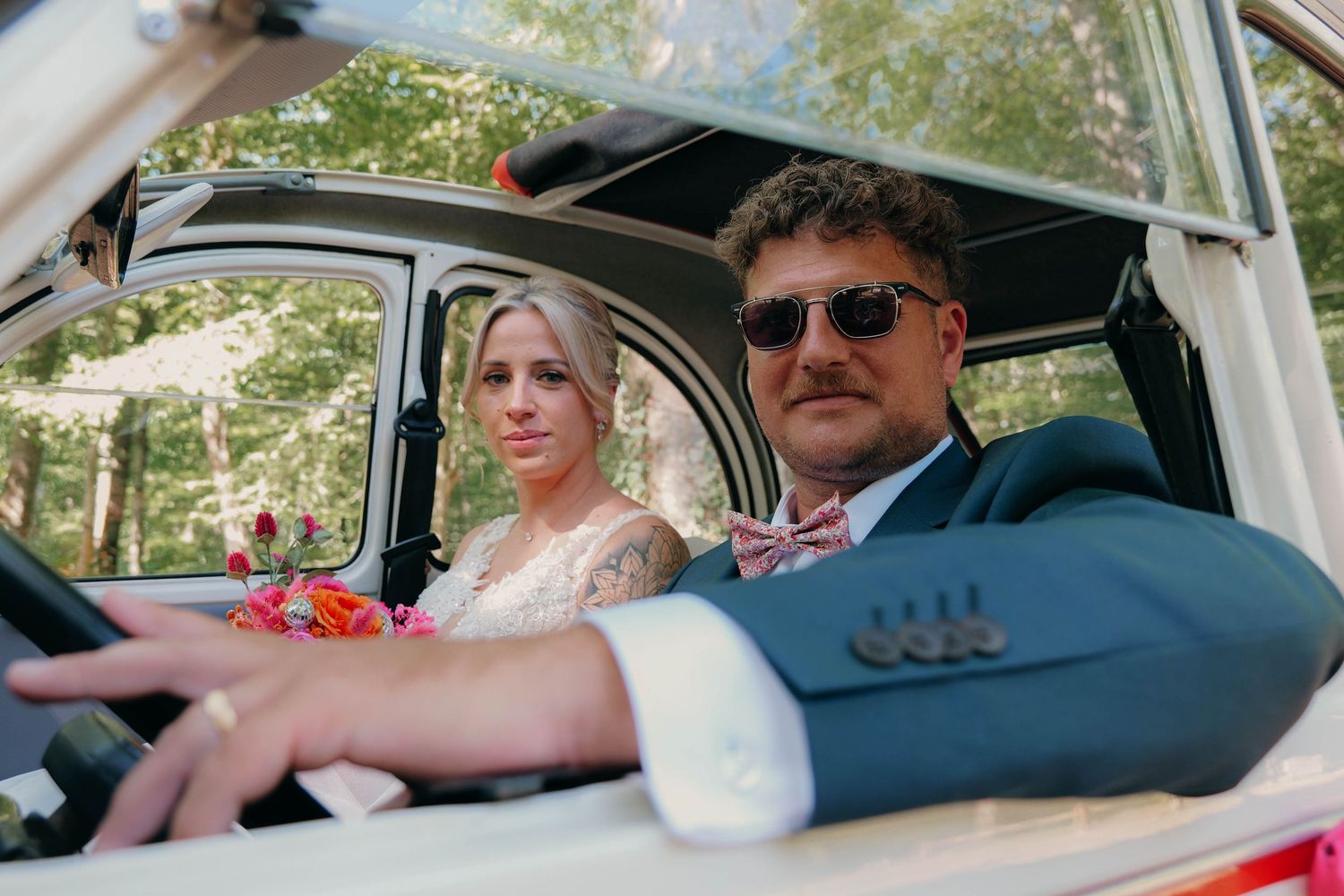 Couple de mariés dans la voiture.