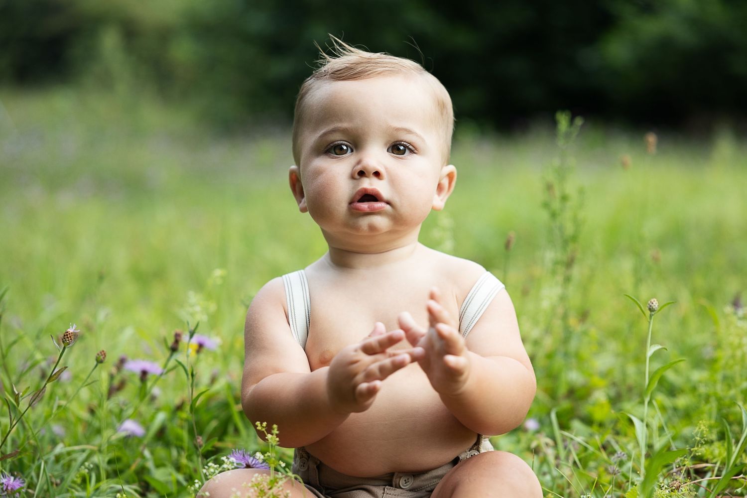 a young child sitting in the grass.