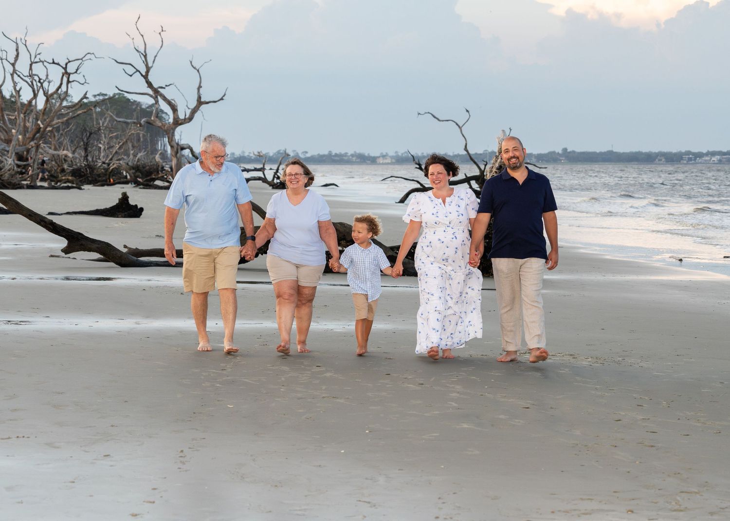 A family of 5 walking towards the camera on Driftwood Beach
