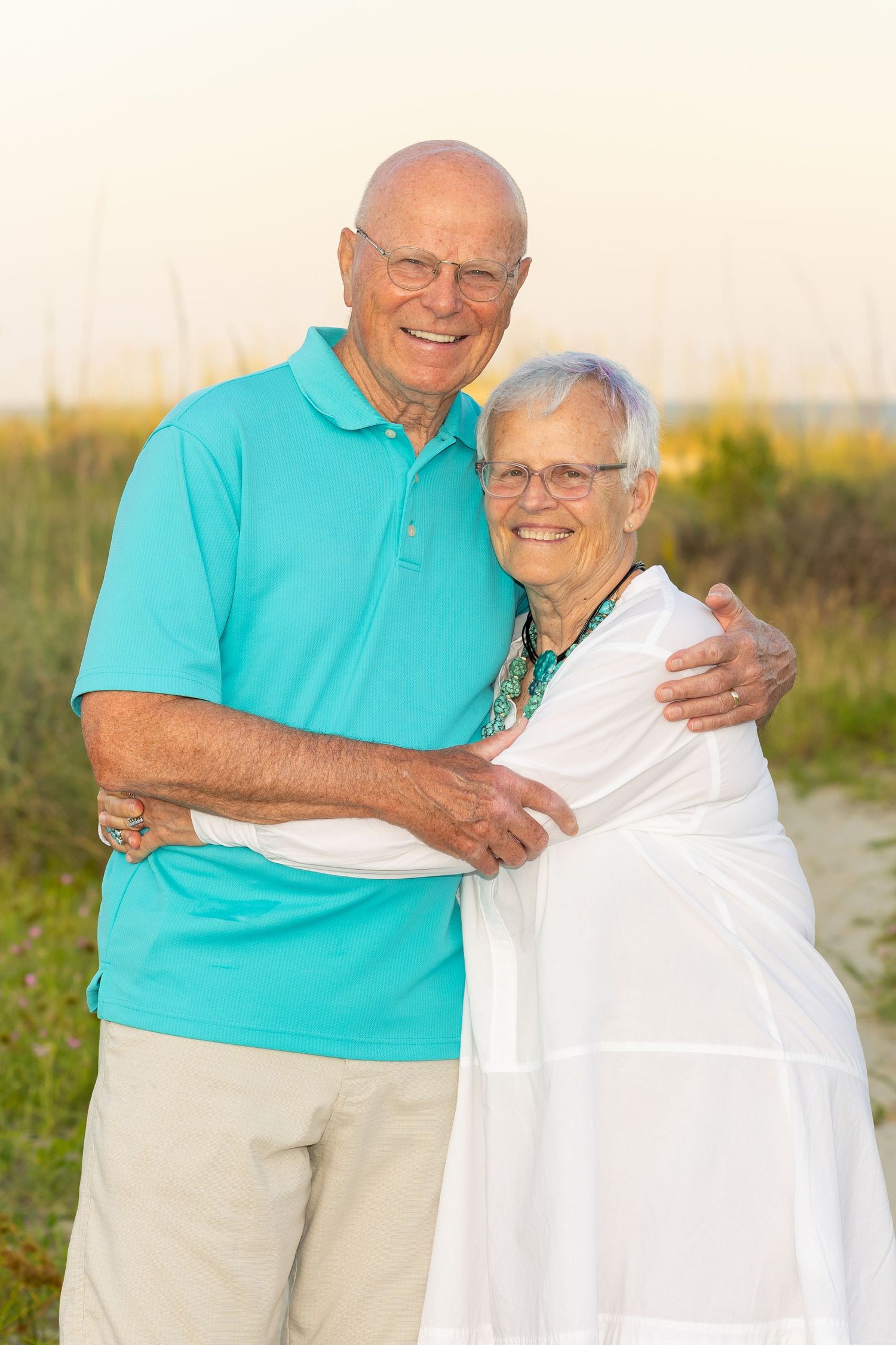 A loving, retired couple hugging each other at the beach.