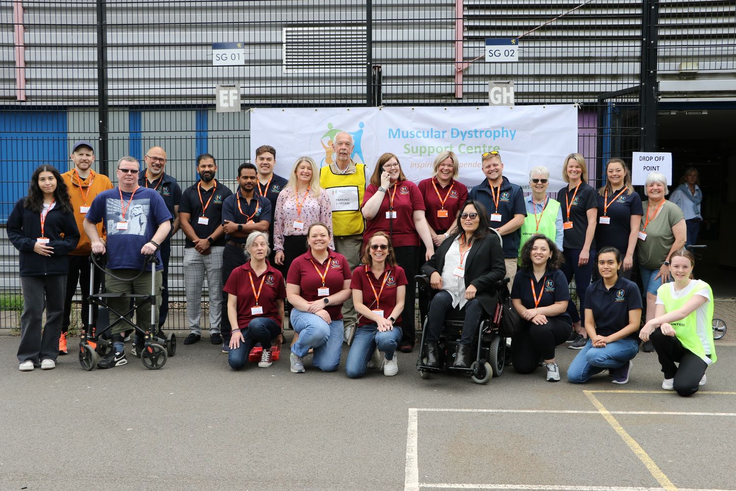 Group photo of community members and staff posed together in an outdoor setting.