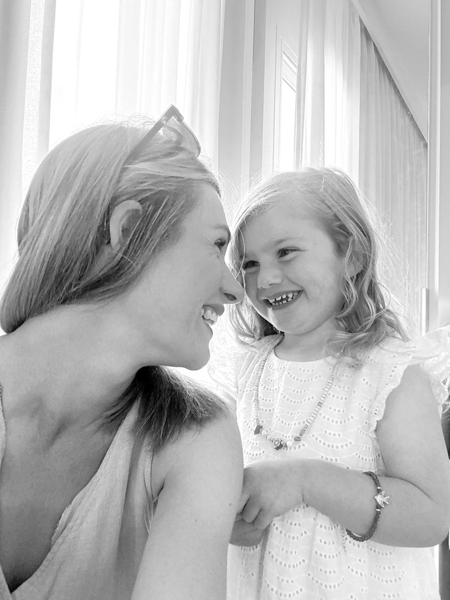 Black and white intimate moment between parent and child sharing laughter.