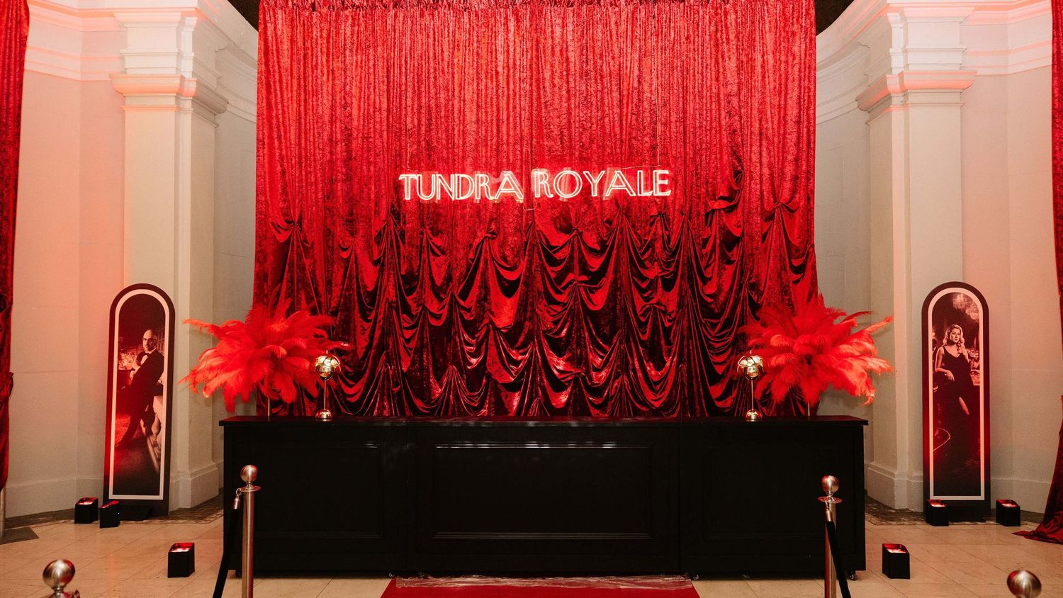 A panoramic view of a theater stage with red curtains and dramatic lighting creating an elegant atmosphere.