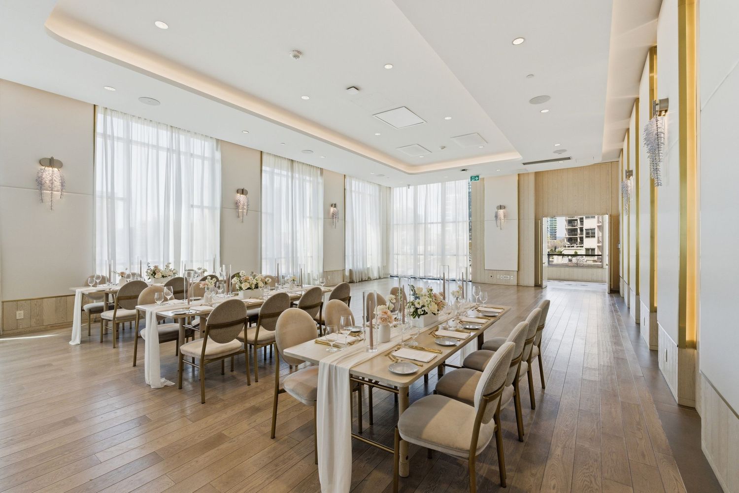 Modern white dining room with panoramic windows featuring contemporary furniture and gold accents throughout the space.