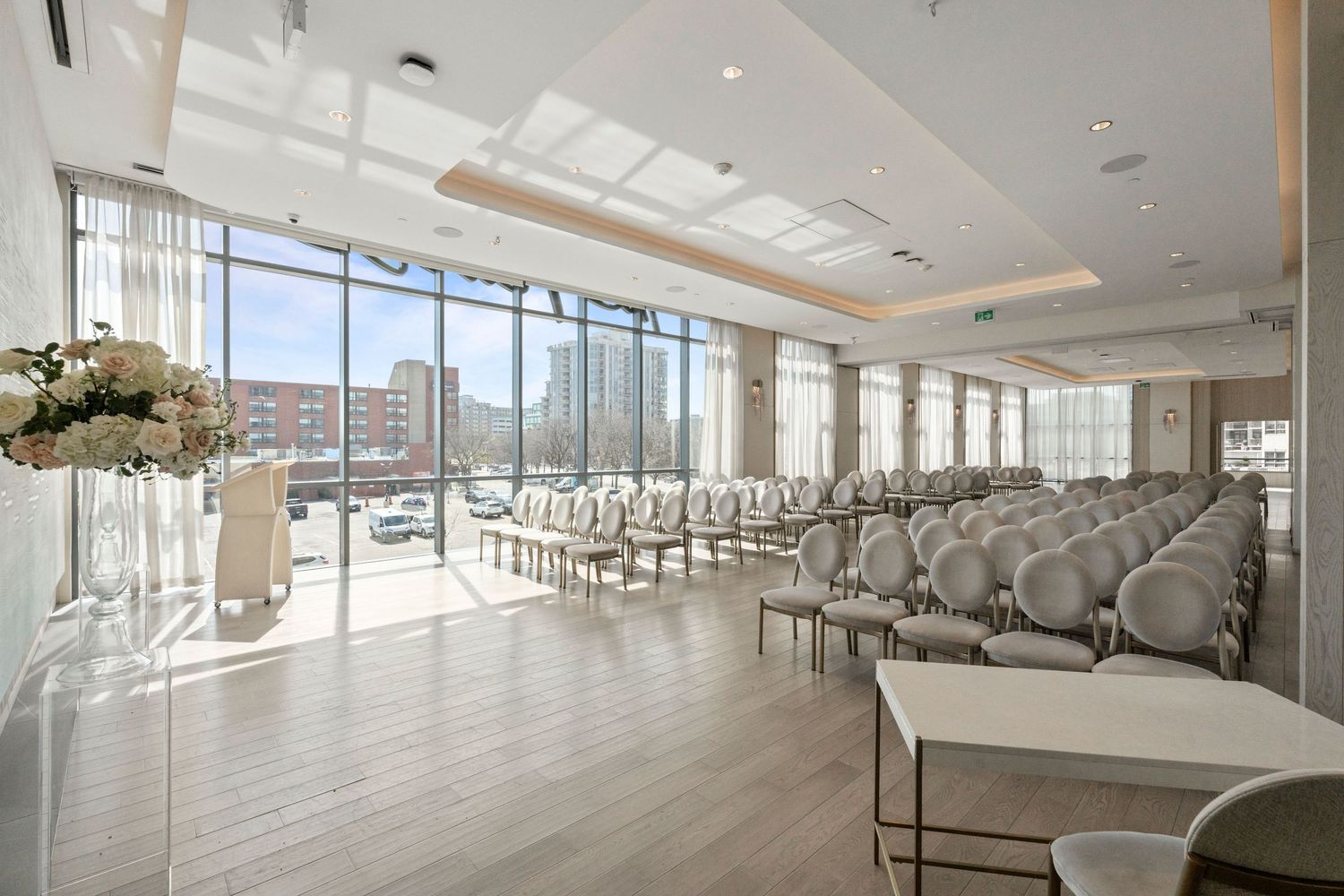 Modern event space with rows of white chairs and floor-to-ceiling windows offering panoramic mountain views.