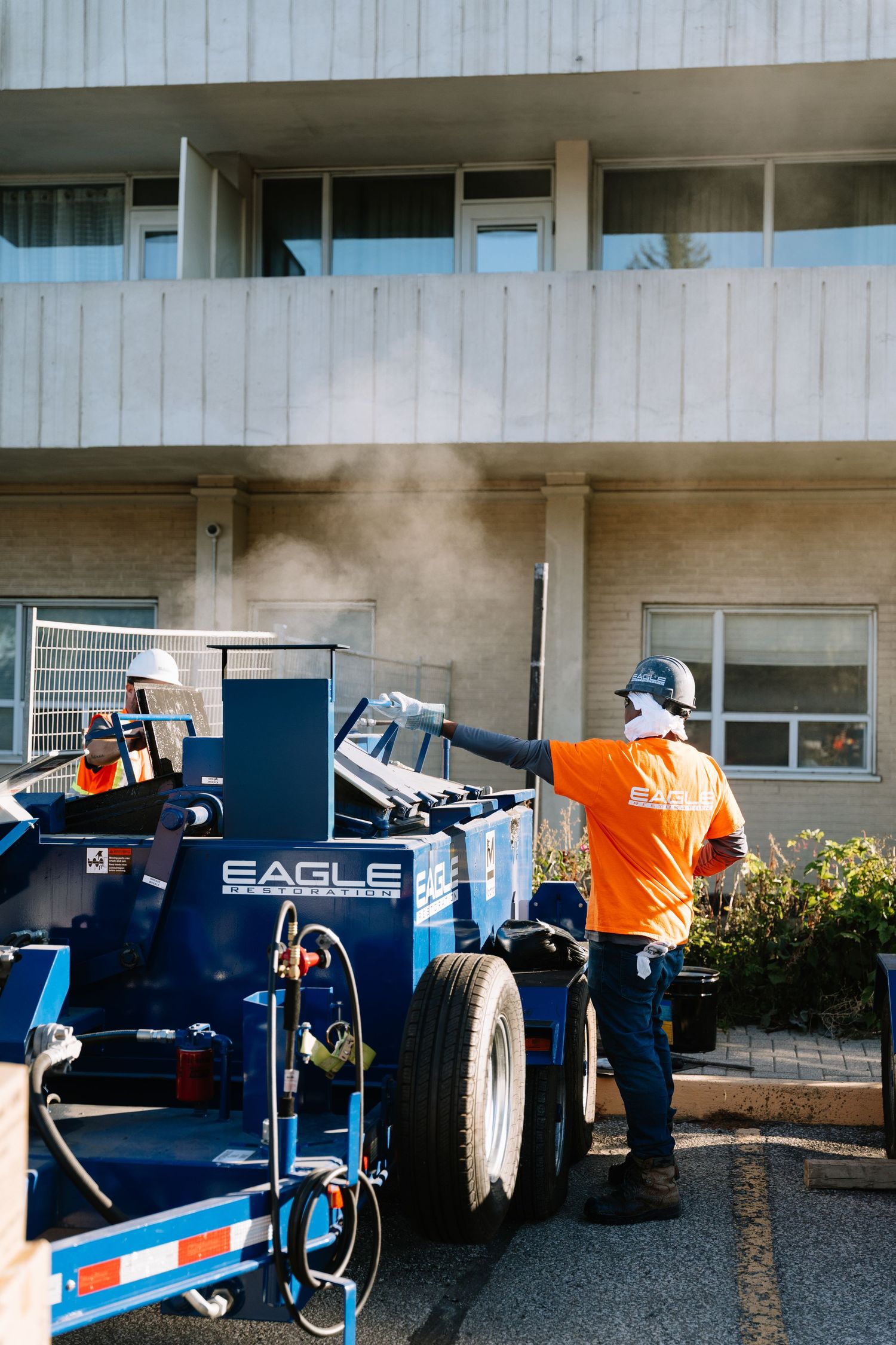 Moving equipment and furniture being loaded into a truck outside a building during a relocation or delivery service.