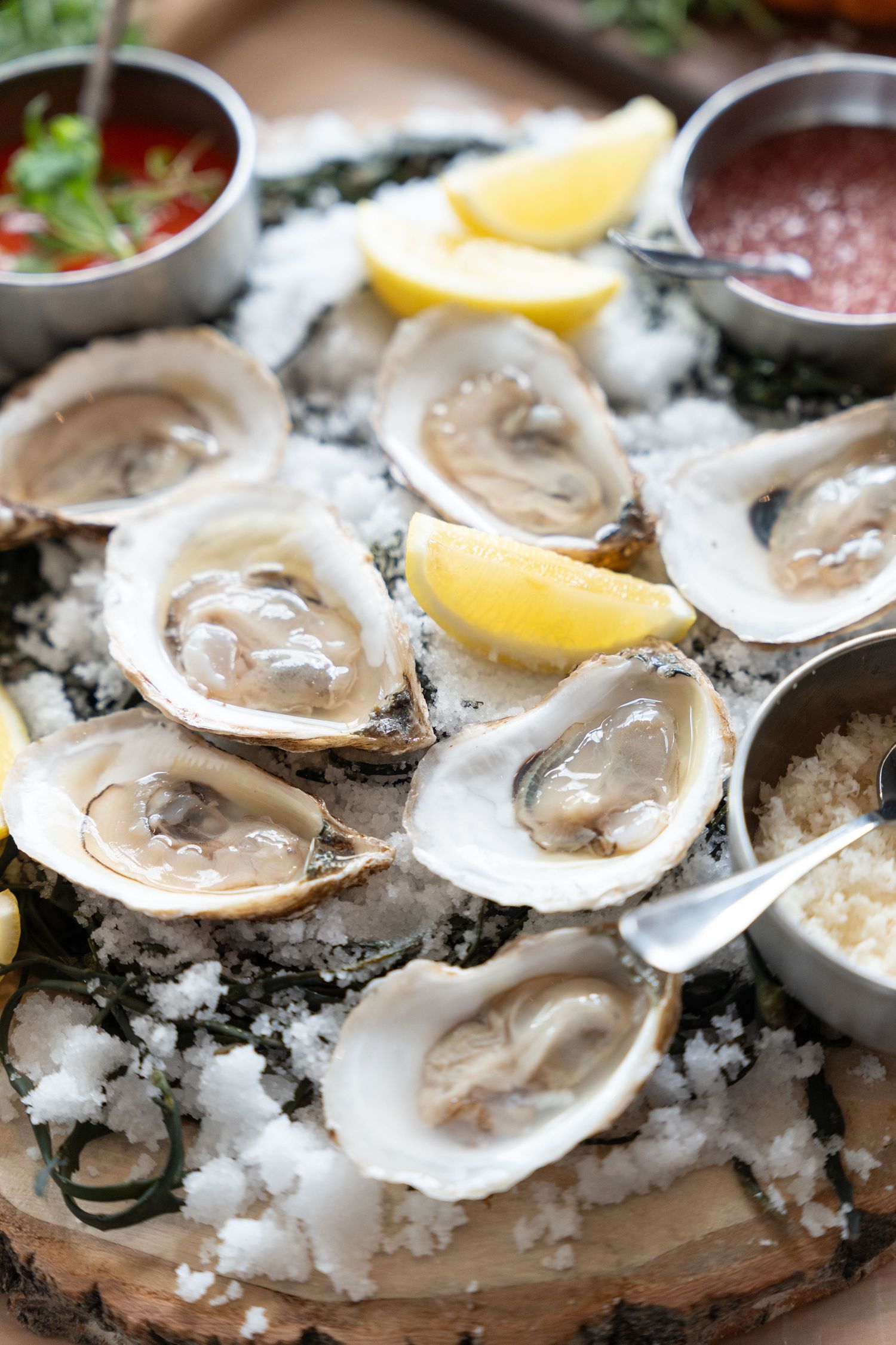 Fresh raw oysters on the half shell served on ice with lemon wedges and cocktail sauce.