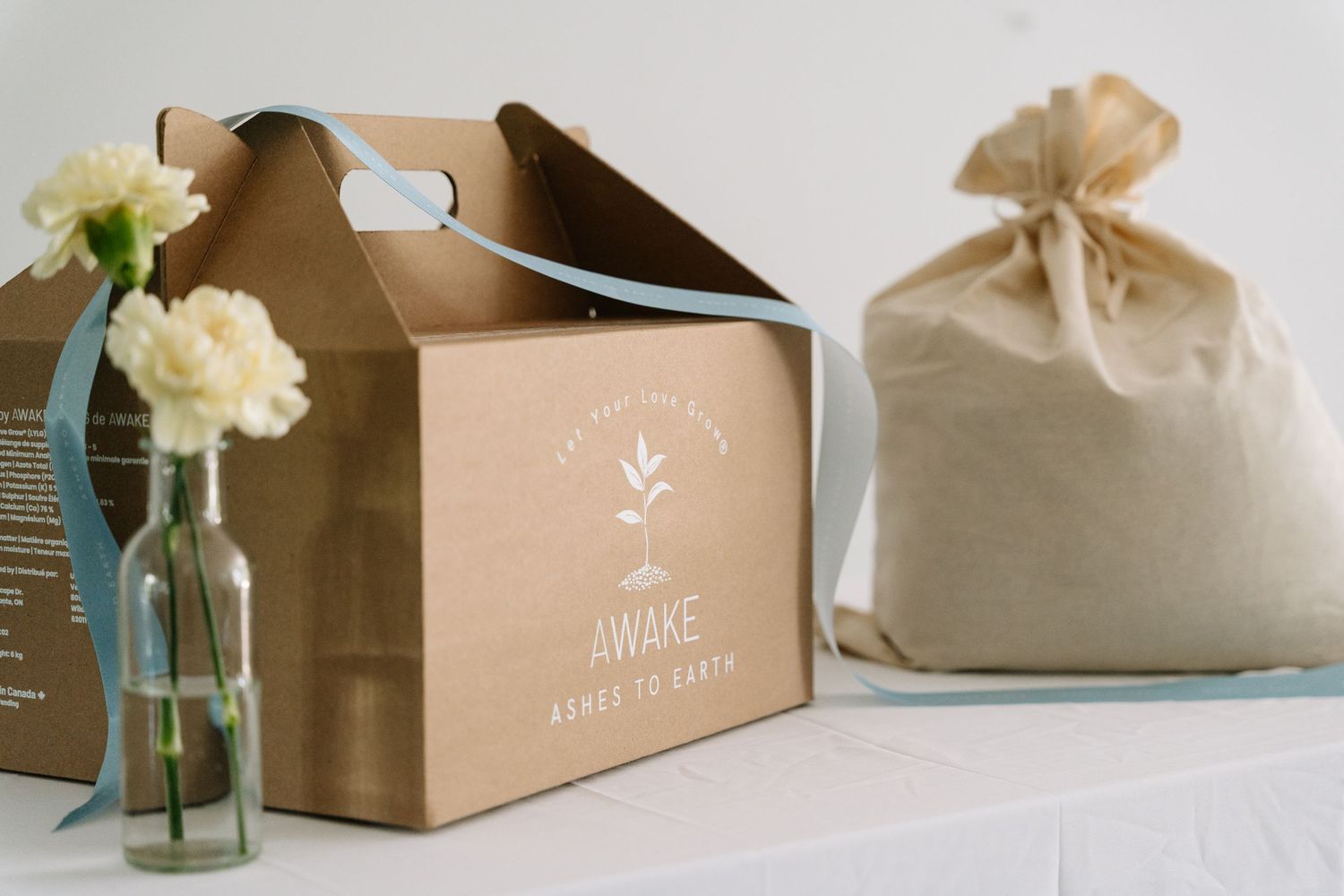 Brown kraft paper gift boxes with delicate floral decorations and ribbons arranged in a minimalist product display.