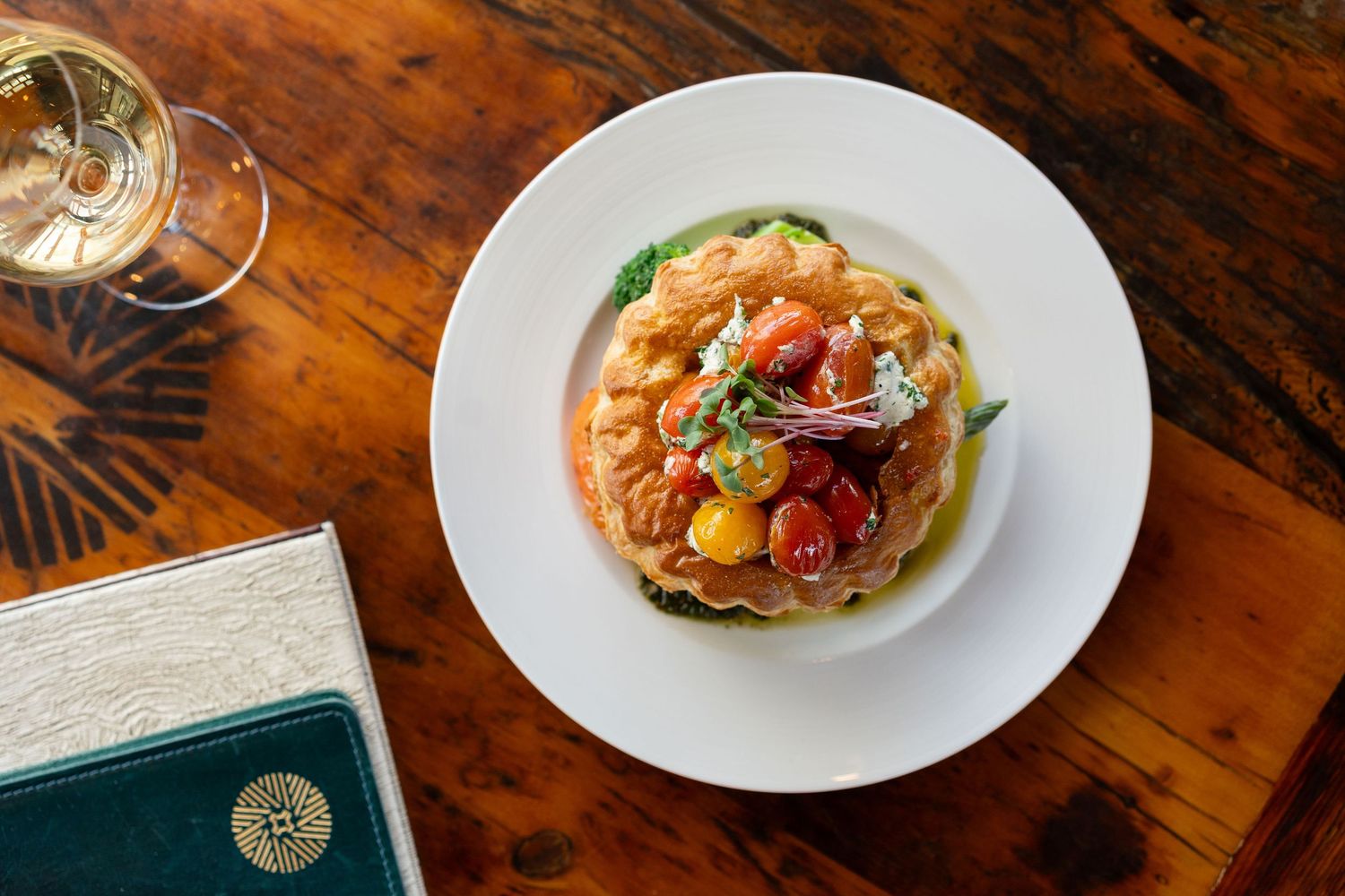 Fresh seafood tostadas with colorful garnishes served on white plates atop a rustic wooden table.