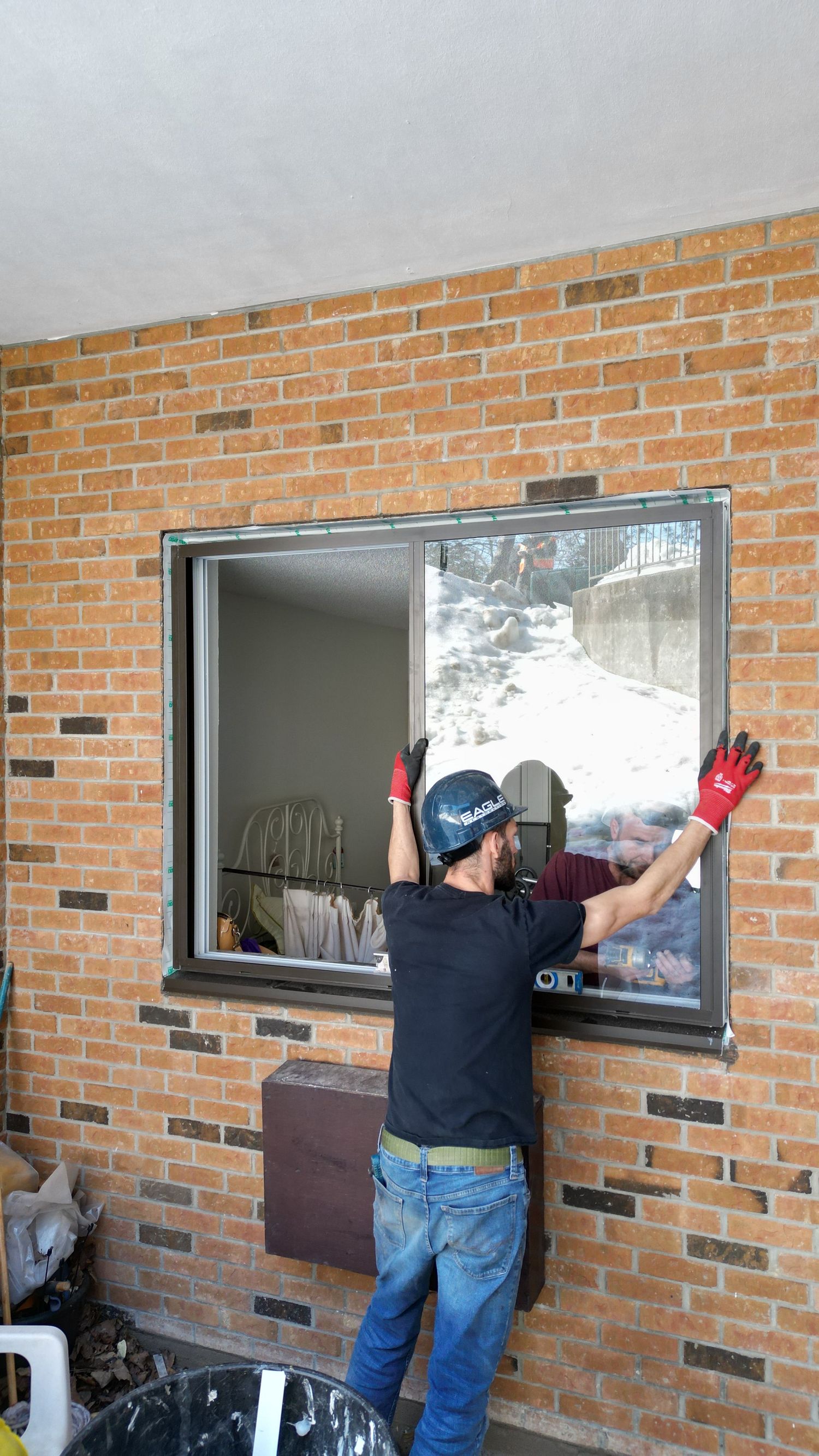 Window cleaning technicians work systematically across a row of apartment windows.