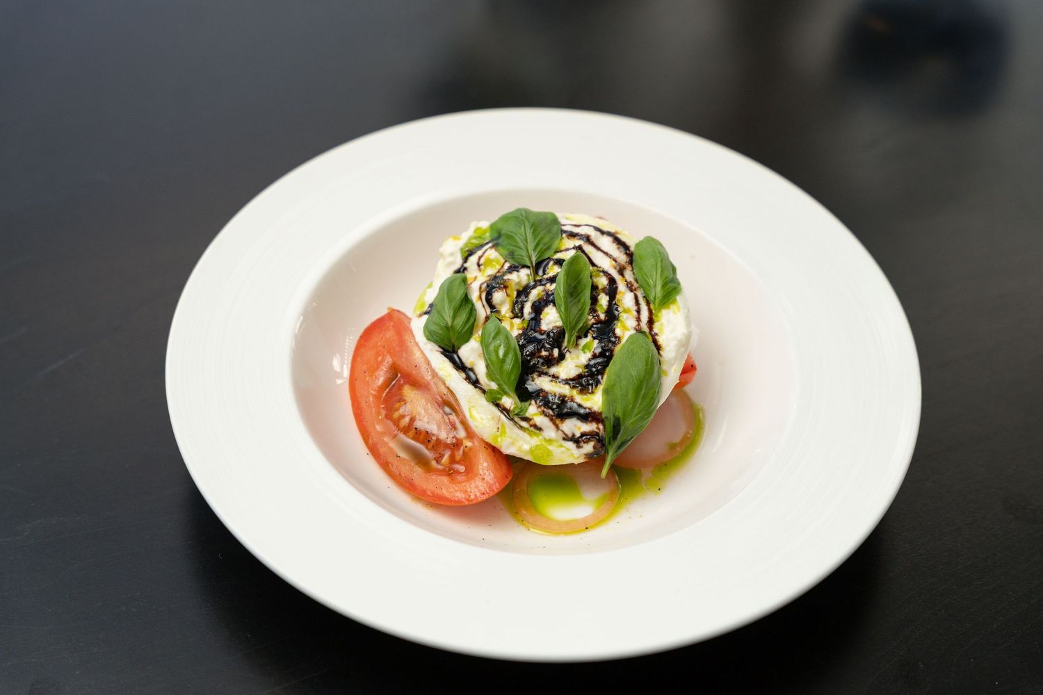 A series of plated dishes featuring tomatoes and microgreens arranged in a modern fine dining presentation style.