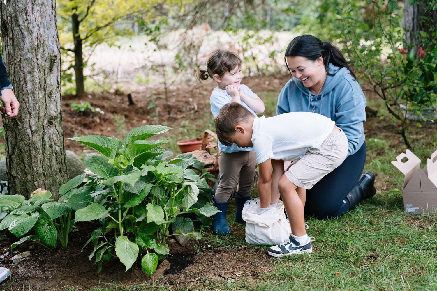 People sitting in a garden setting while planting and tending to outdoor plants and greenery.