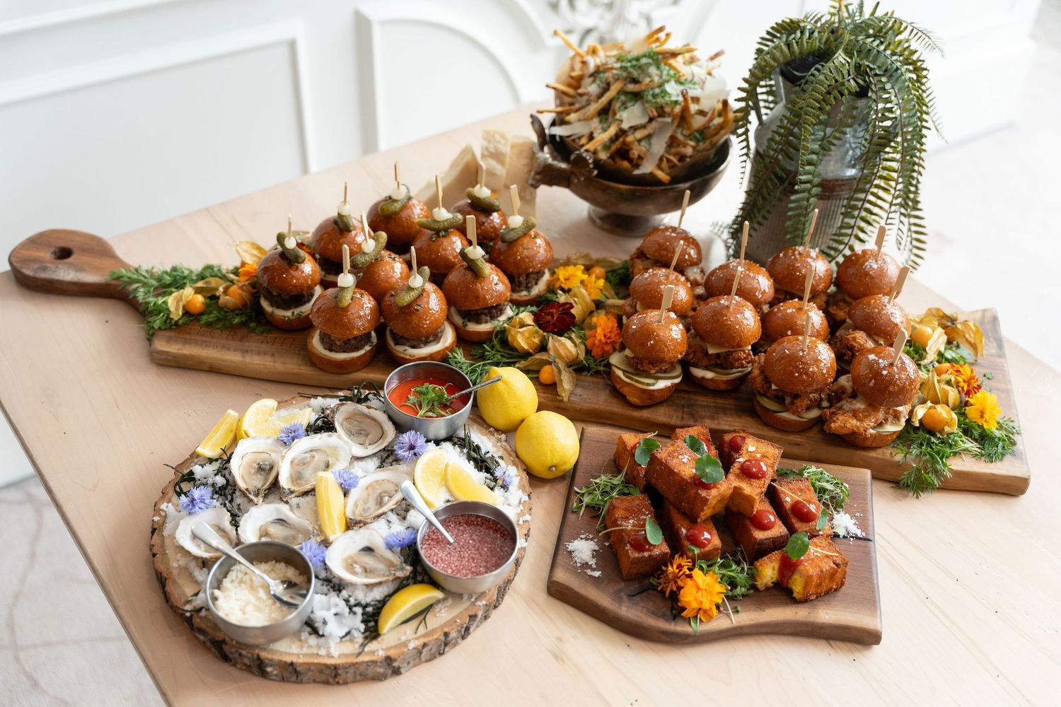 Elegant appetizer platters with fresh seafood, fruits, and garnishes arranged on rustic wooden serving boards.