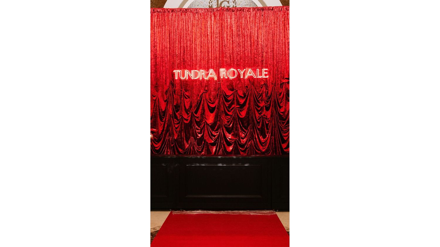 Red theatrical curtain with dramatic lighting creates an elegant stage backdrop.