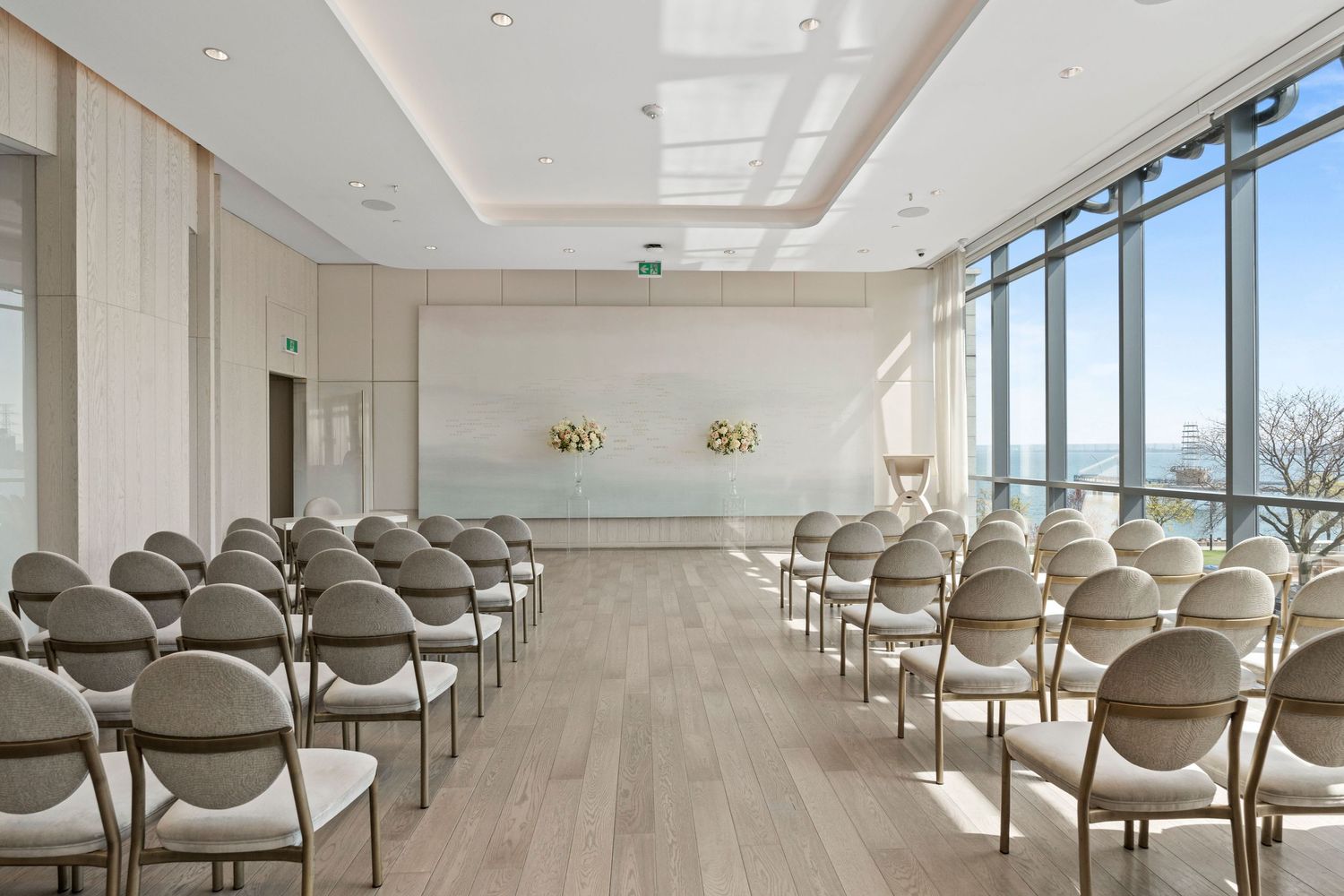 Modern conference room with rows of gray chairs and large windows offering natural light and panoramic views.