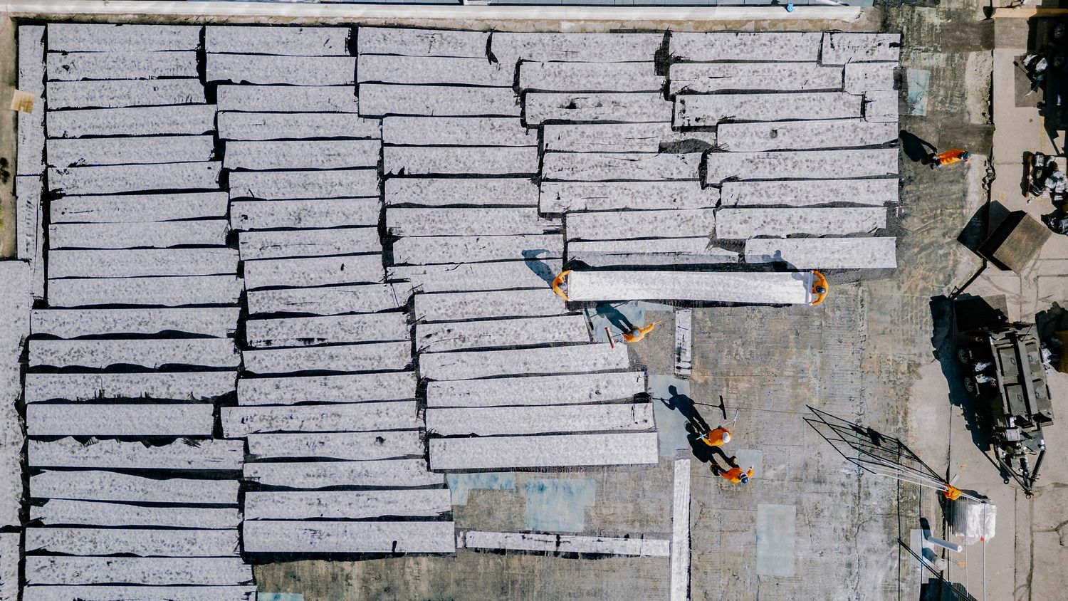 Aerial view of large industrial warehouse rooftops with skylights in a commercial district.