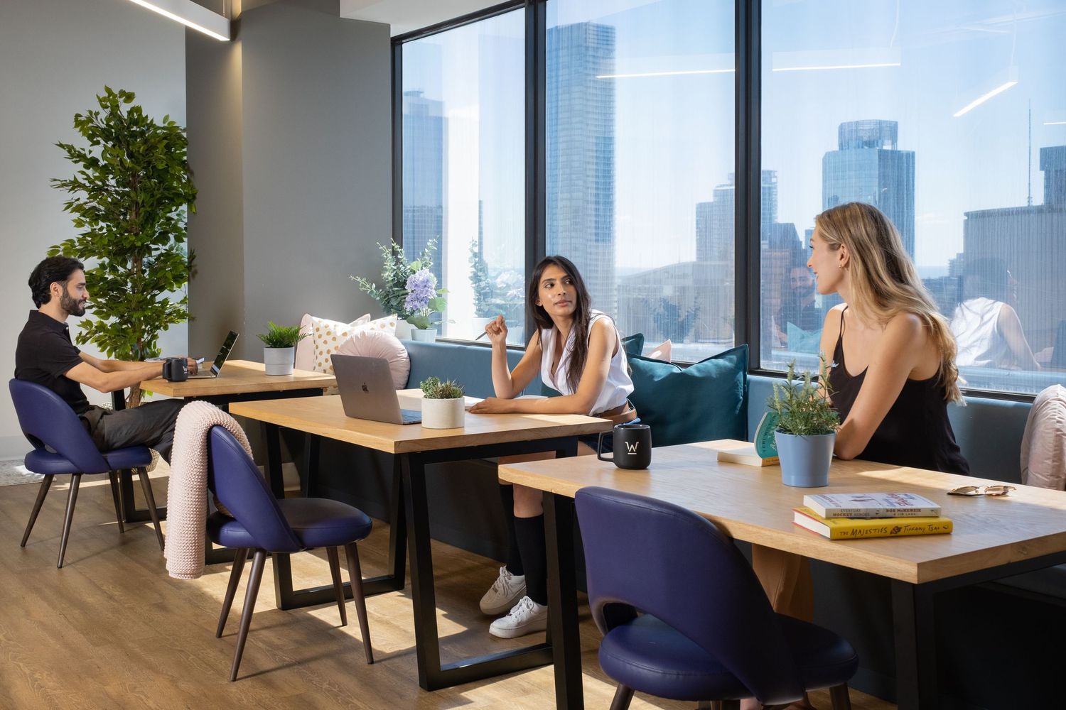 Modern office space with comfortable seating areas and large windows overlooking city skyline.