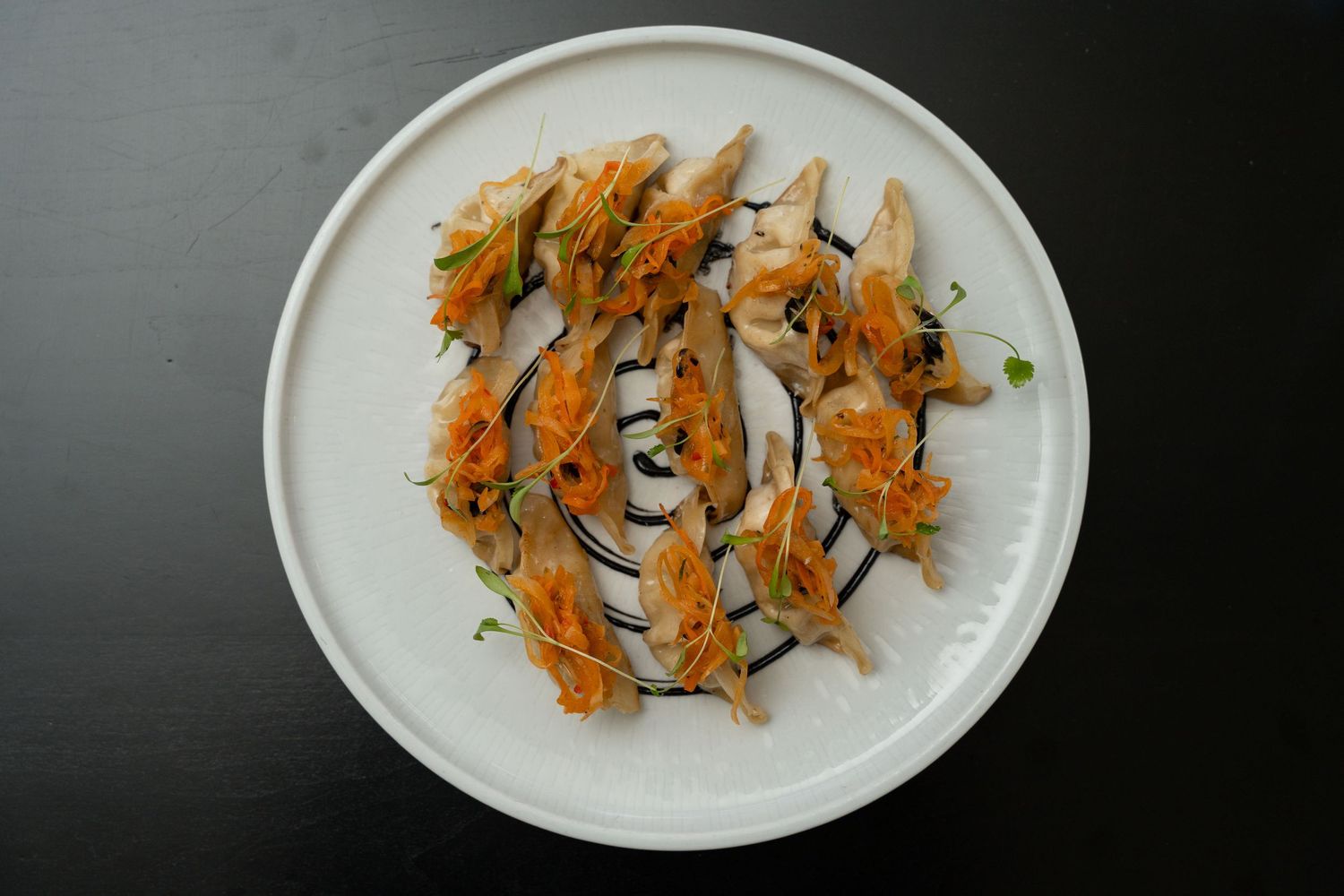 Sliced sushi rolls with orange toppings and garnishes presented on white oval serving plates.