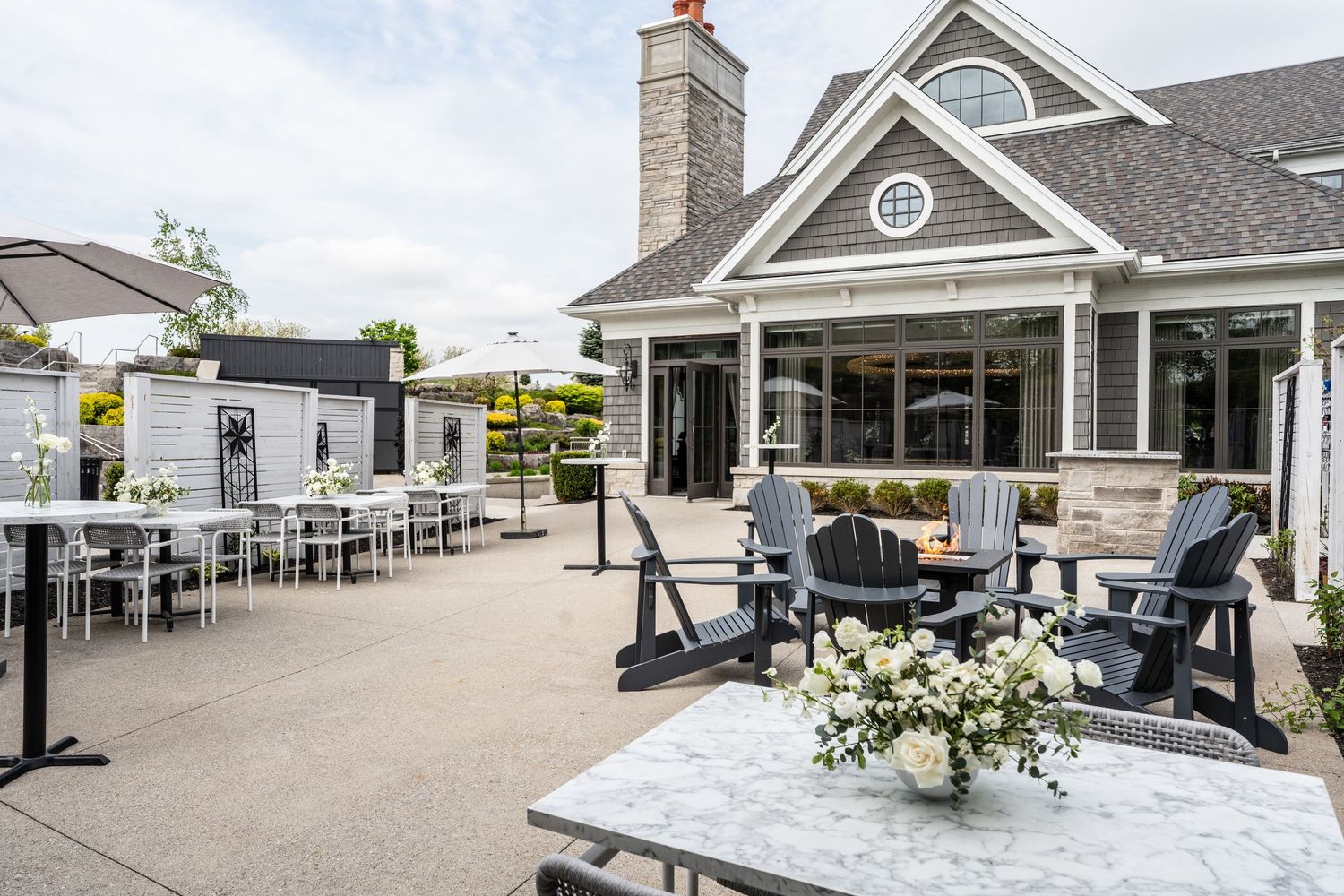 Panoramic view of a luxury waterfront home exterior with multiple decks and outdoor seating areas.