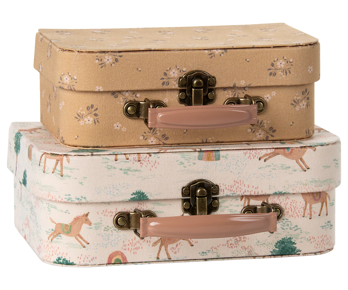 Two vintage style decorative suitcases with animal print designs stacked on top of each other with brass clasps and handles.