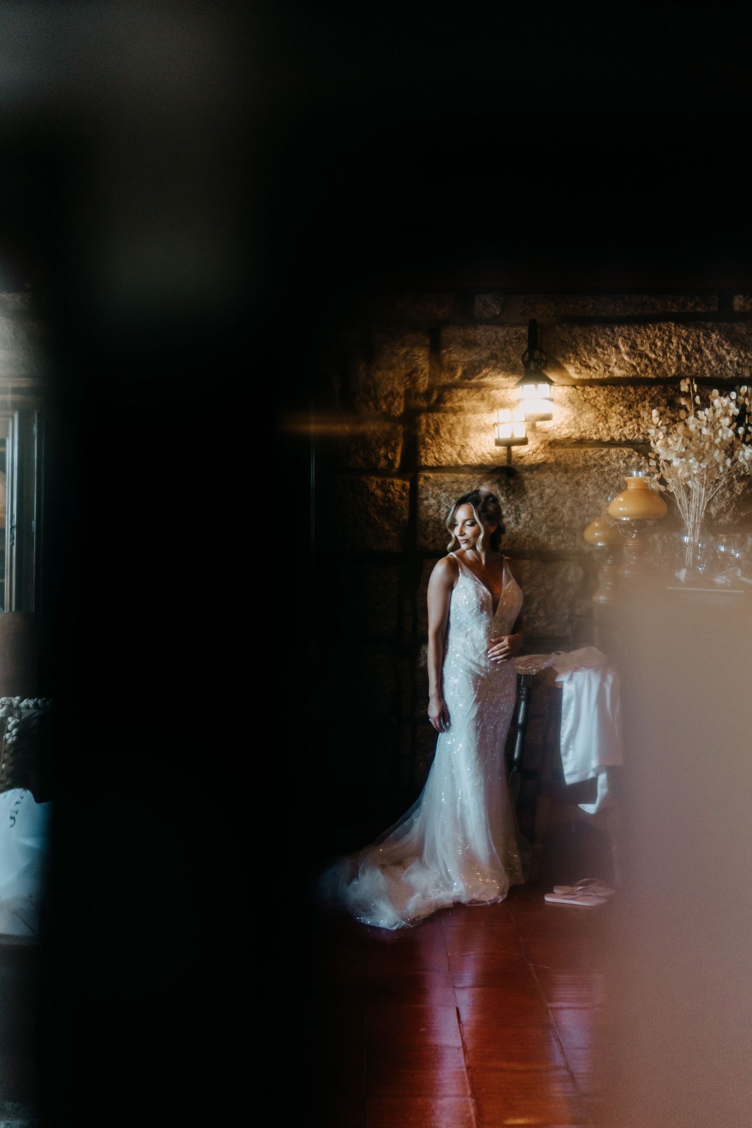A romantic dance sequence in low light captured at a wedding reception with soft lighting and stone wall decor.