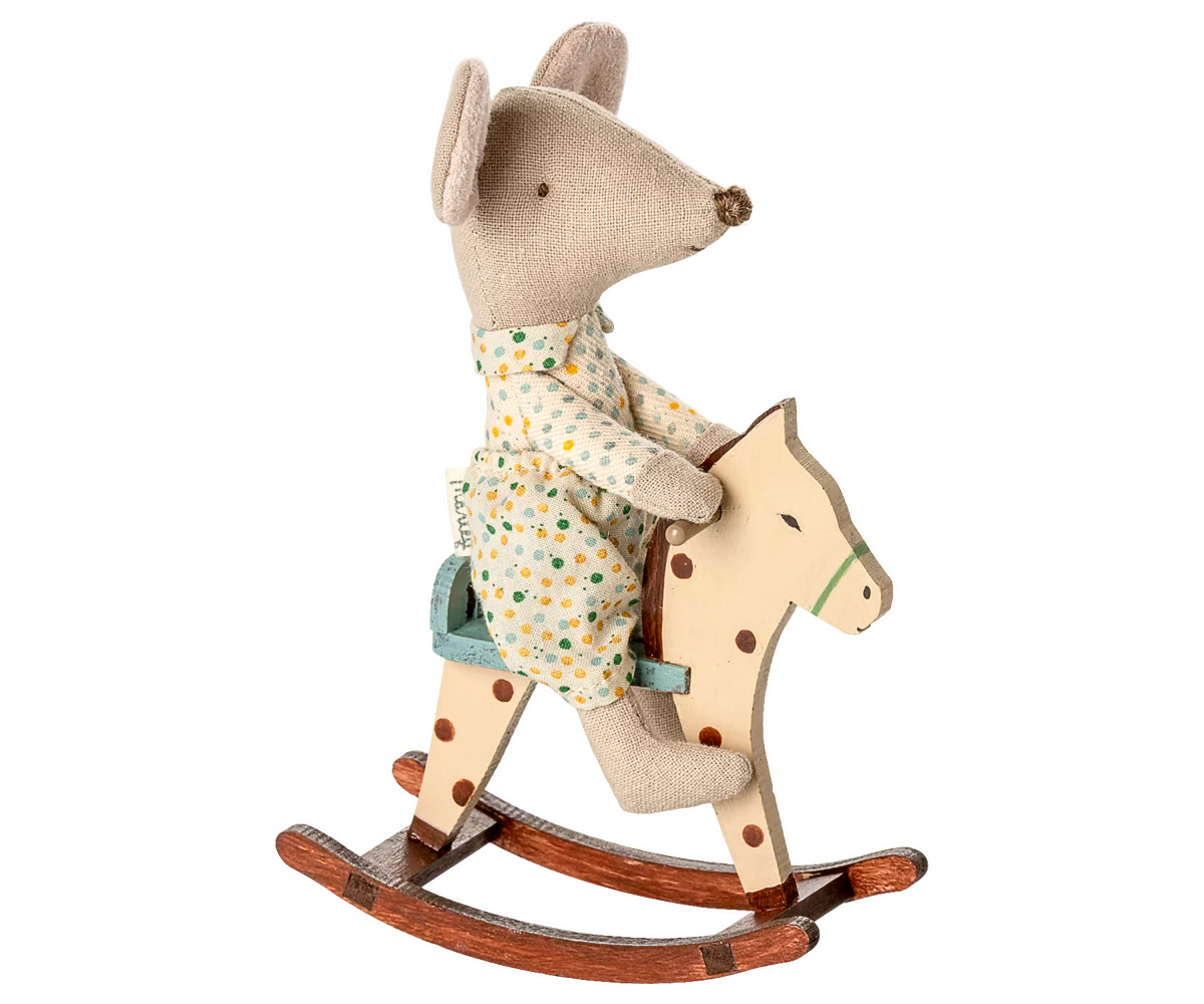 Plush mouse toy riding a wooden rocking horse wearing a floral dress and brown shoes.
