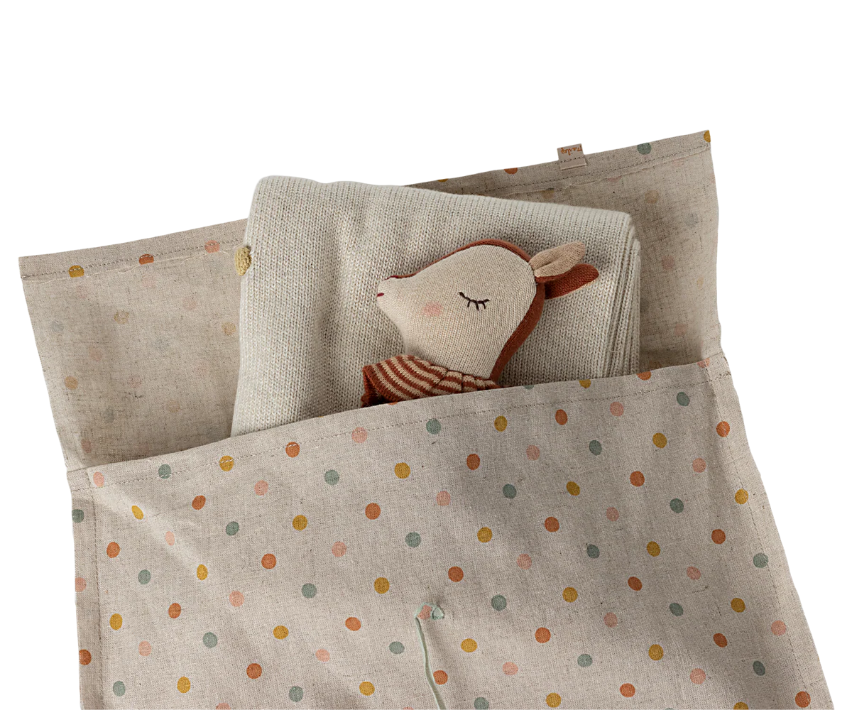 Polka dot gift bags with handles arranged in a row on white background.