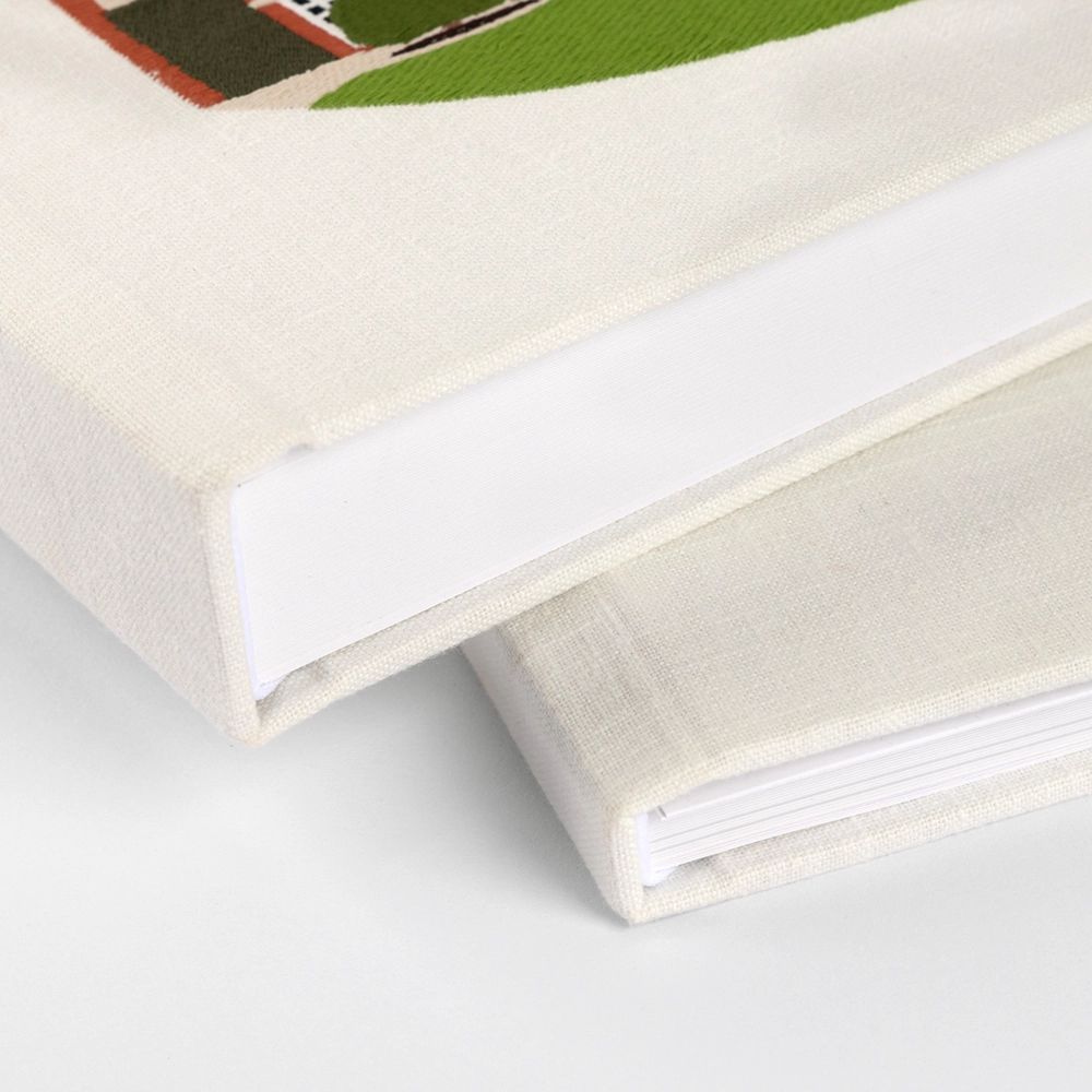 Close-up view of white album pages or book spines stacked showing textured paper and binding details.