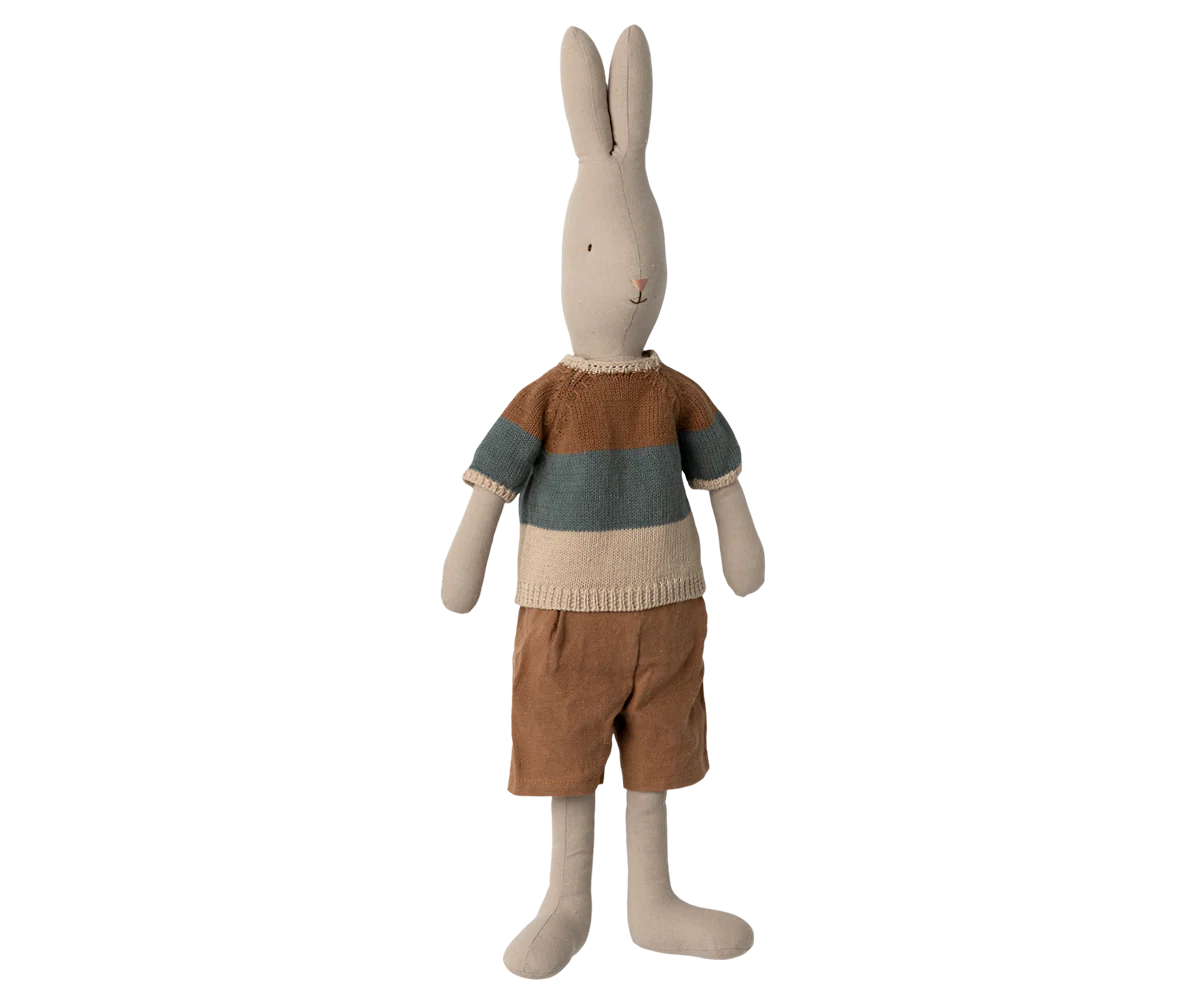 A line of plush bunny toys wearing casual clothing like sweaters and shorts displayed against a white background.