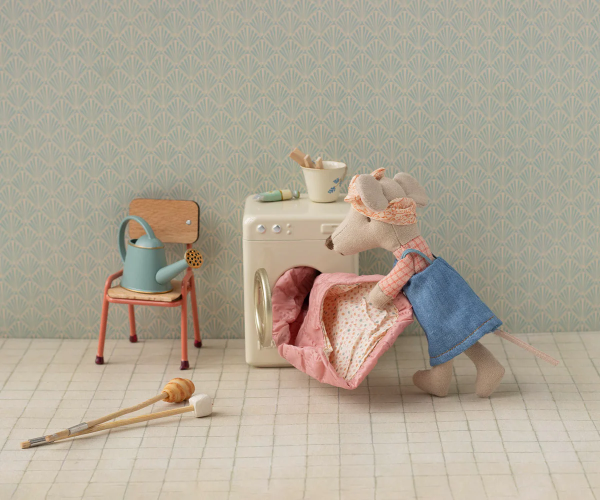 Still life scene with vintage chair, dresser, and scattered clothing items on tiled floor in pastel colors.