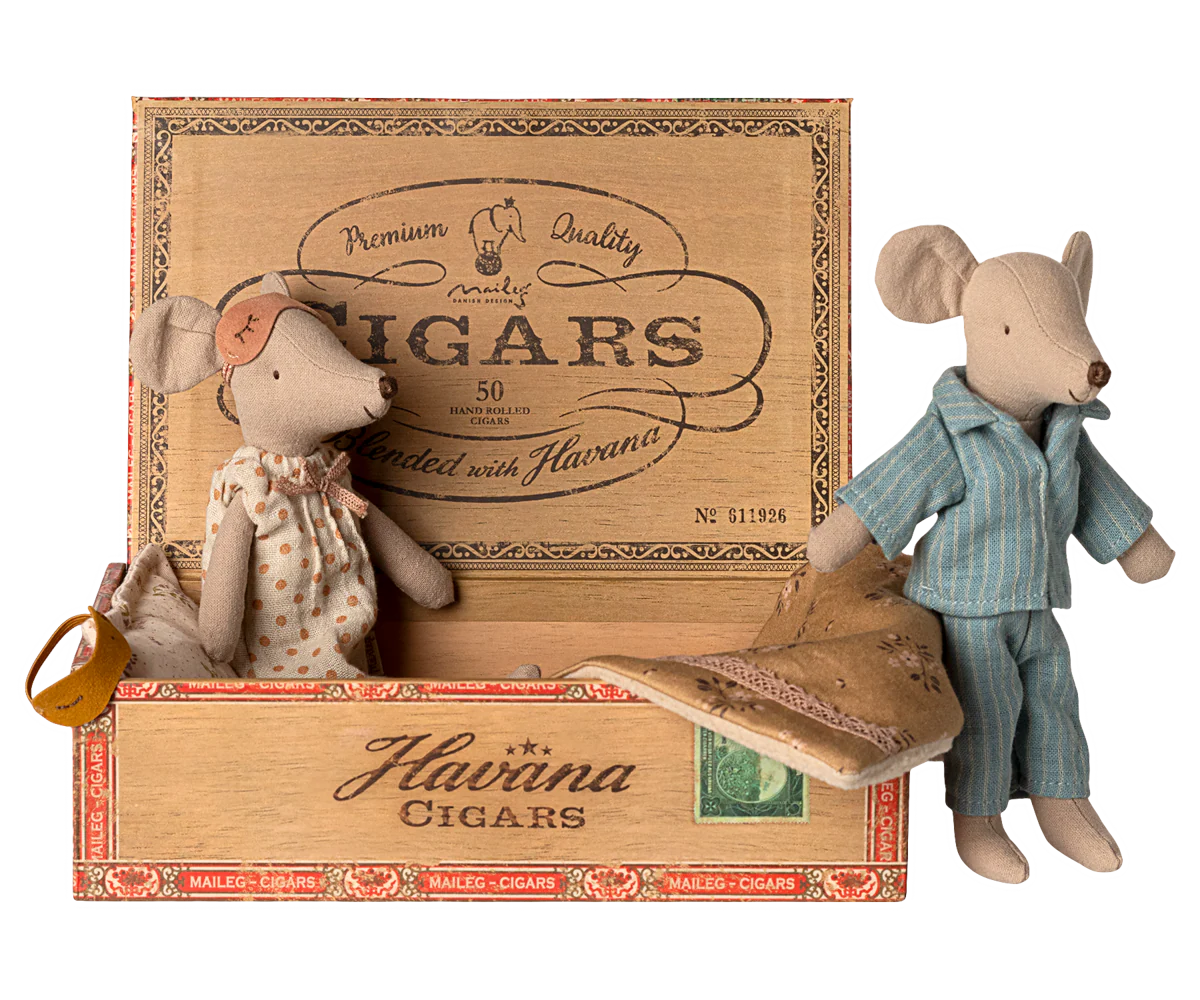 A collection of vintage cigar boxes and small toy mice arranged in a horizontal line against a white background.